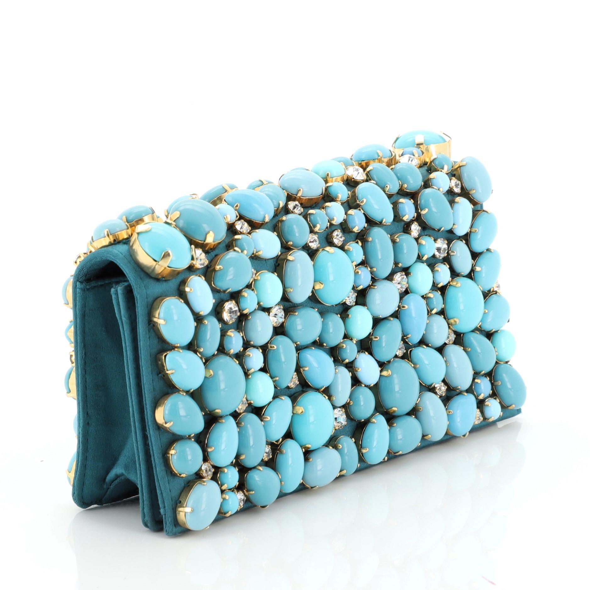 This Prada Raso Pietre Clutch Embellished Satin, crafted from green embellished satin, features tonal stones embellishment. Its snap closure opens to a green satin interior with slip pocket. 

Estimated Retail Price: $2,500
Condition: Very good.