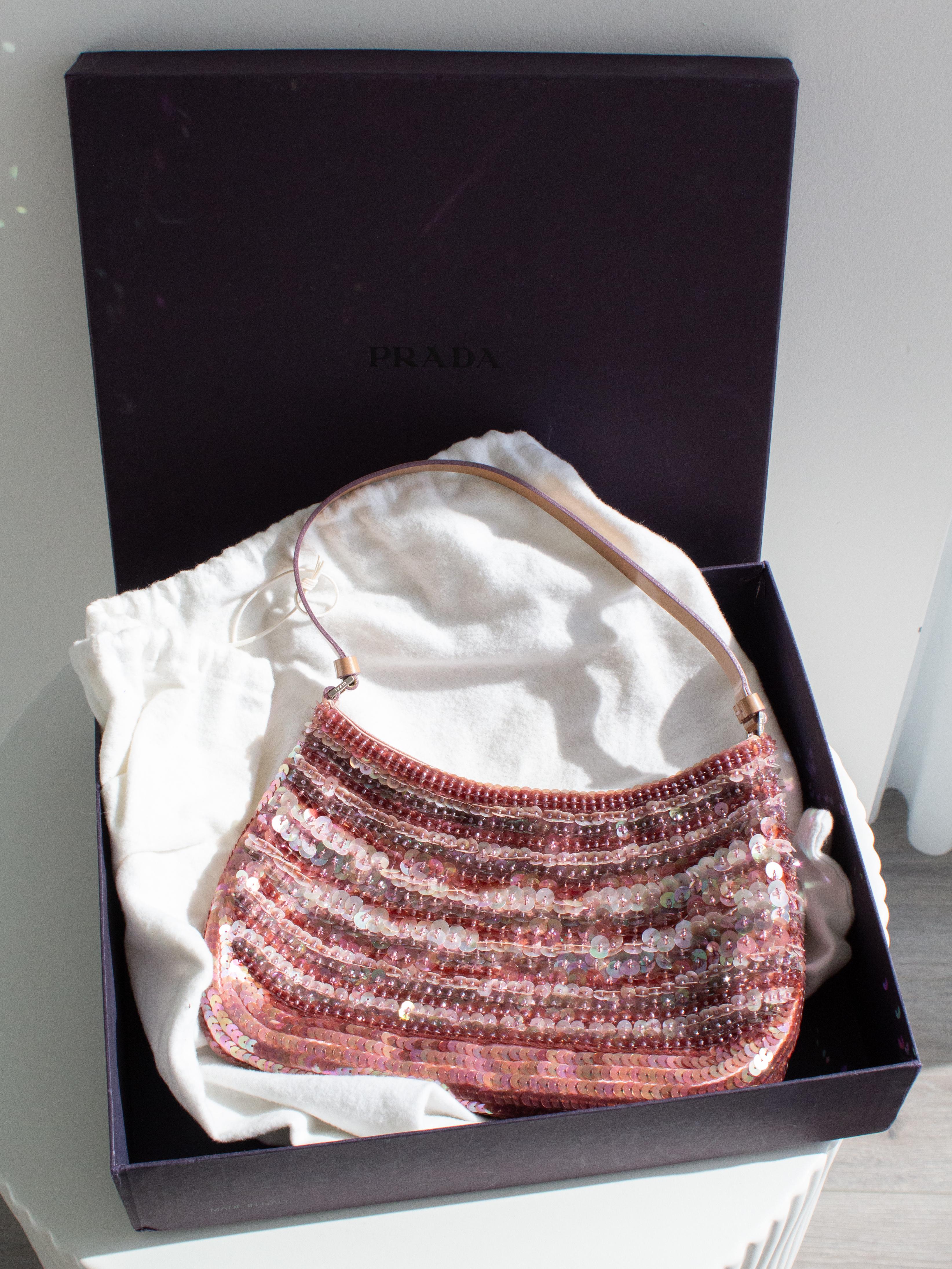 This Prada Raso bag in the dreamy Petalo mauve pink shade is the most sought-after vintage Prada piece of the year, seen on top social media influencers. A true collector’s gem, this bag is crafted from delicate satin silk and adorned with