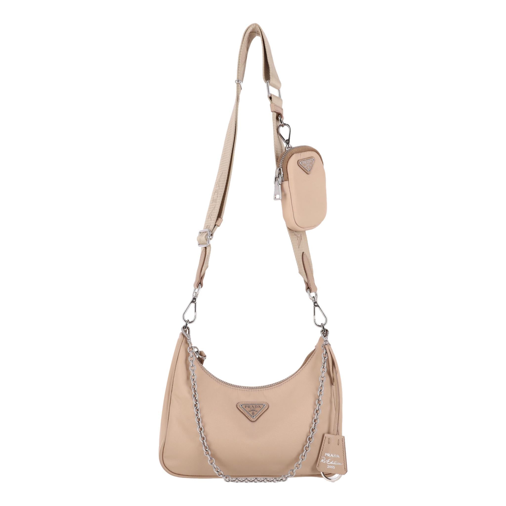 Prada Re-Edition 2005 Re-Nylon Shoulder Bag

Beige bag made from recycled nylon with signature 'Prada' triangle logo to the centre.

Detailed with silver hardware and branded, removable pouch and keychain.

Featuring detachable silver chain handle,
