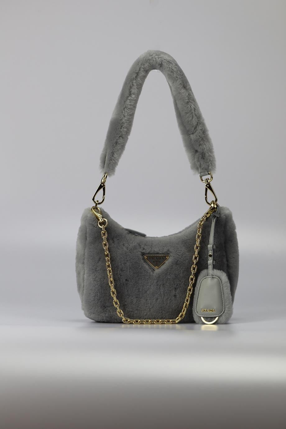 Prada Re-edition Shearling And Leather Shoulder Bag. Grey. Zip fastening - Top. Comes with leather shoulder strap. Comes with - authenticity card. Does not come with - dustbag or box.. Height: 6.7 In. Width: 9.2 In. Depth: 3.1 In. Handle drop: 10.3
