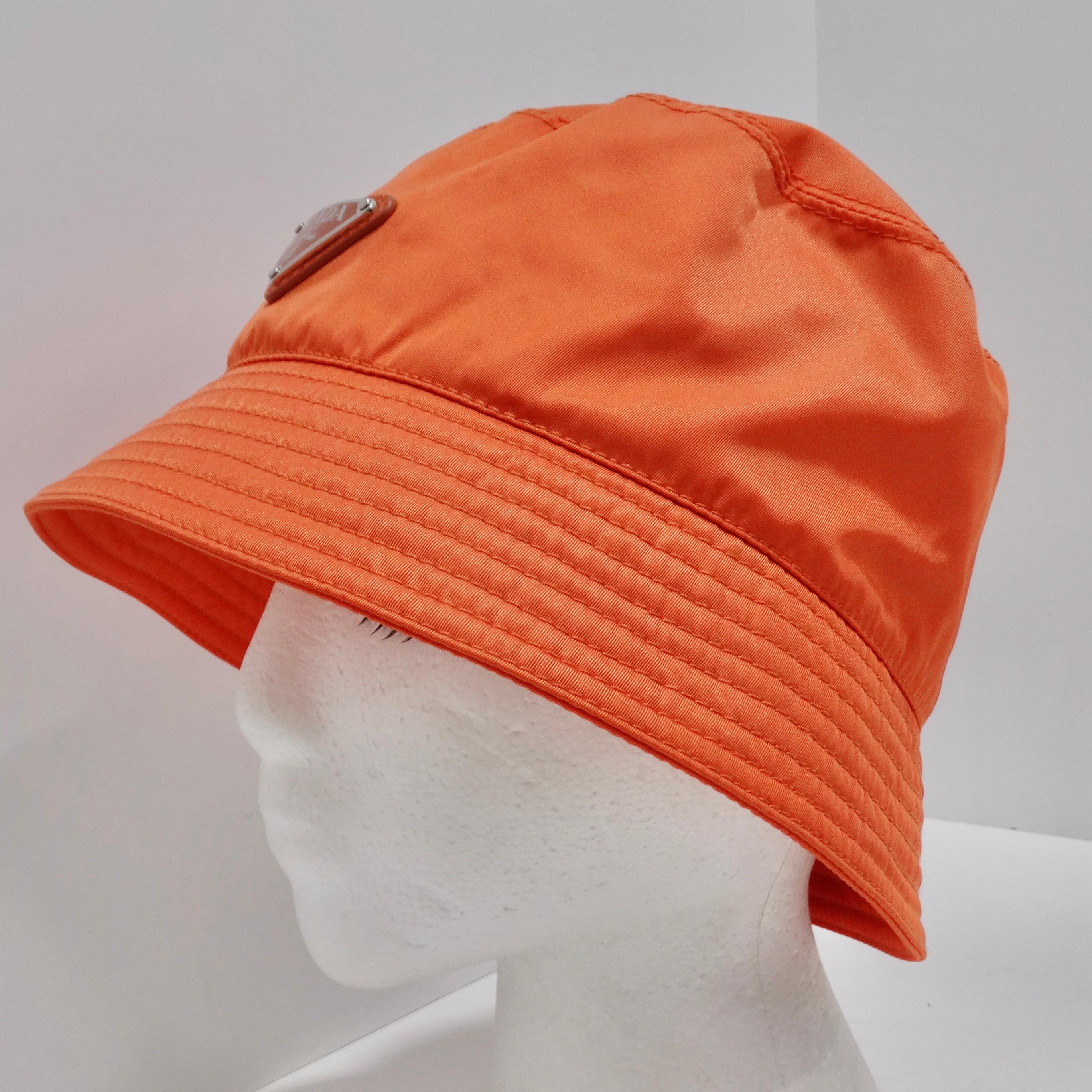 
Élevez votre style et faites une déclaration écoconsciente avec le chapeau Bucket en re-nylon de Prada, d'un orange vibrant. Ce chapeau seau classique présente la fusion parfaite de la mode et de la durabilité, ce qui en fait un accessoire