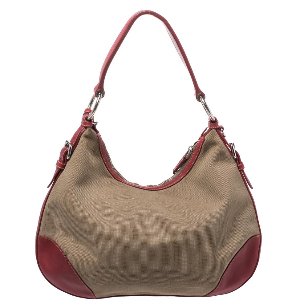 This bag is lined with nylon that allows you to keep your essentials safe. Make a style statement with this fabric and leather hobo. Designed by Prada, the bag has a single handle, the logo on the front and a convenient size.

