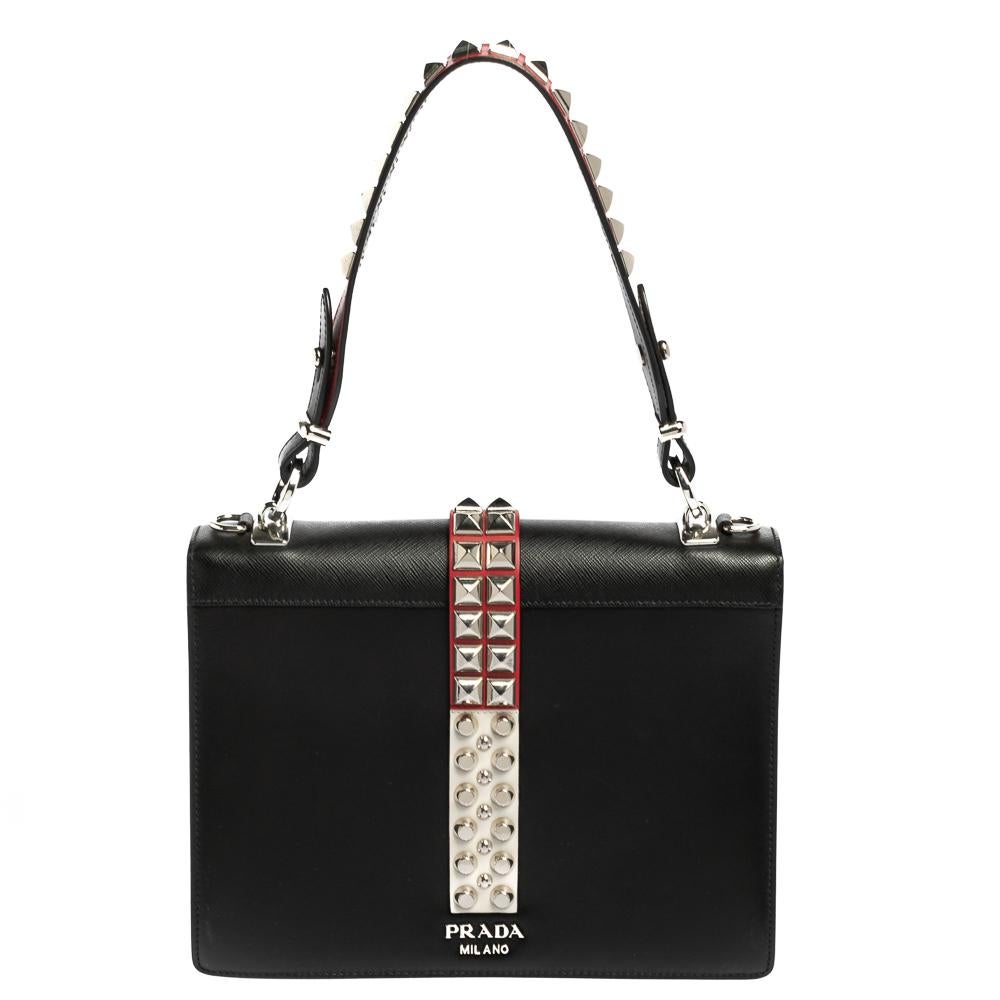 Crafted using leather, this creation in red and black is designed to easily hold all your little essentials. The Elektra shoulder bag by Prada features a trim of studs along the middle of the bag and a leather interior. It has a studded top handle