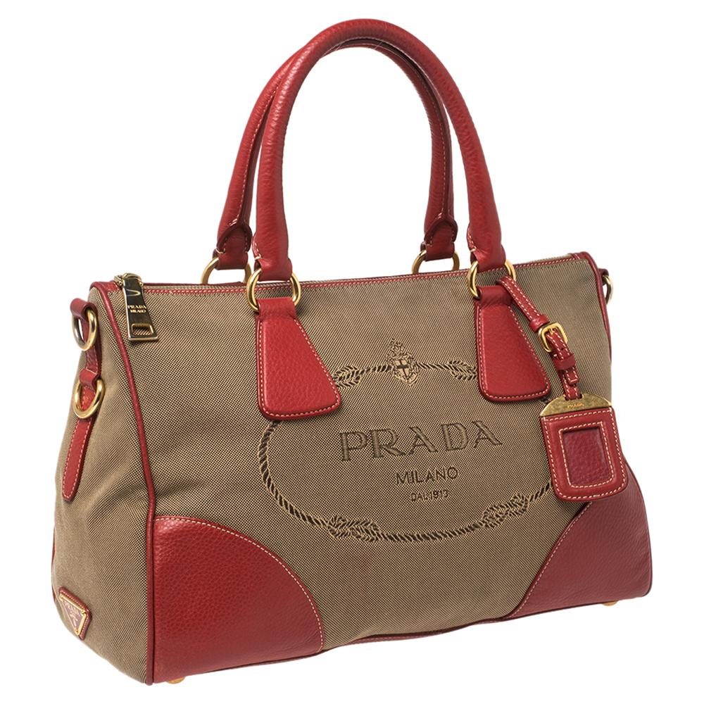 Add a dash of elegance to your look with this stylish satchel from Prada. This canvas and leather bag is an ideal pick for all your essentials. Two handles and a nylon interior add to the functional charm of the handy bag.

Includes: Original