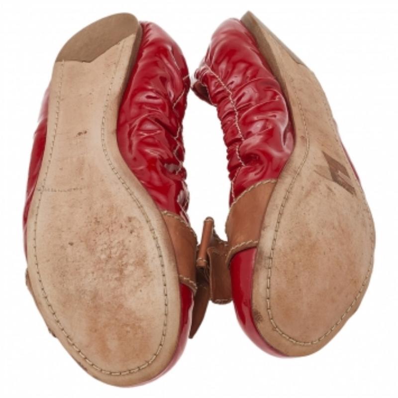 Chic and fashionable, these ballet flats from Prada are perfect for channeling an air of elegance. These red and brown flats are crafted from patent leather and feature round toes with bow detailing. They come equipped with leather-lined comfortable