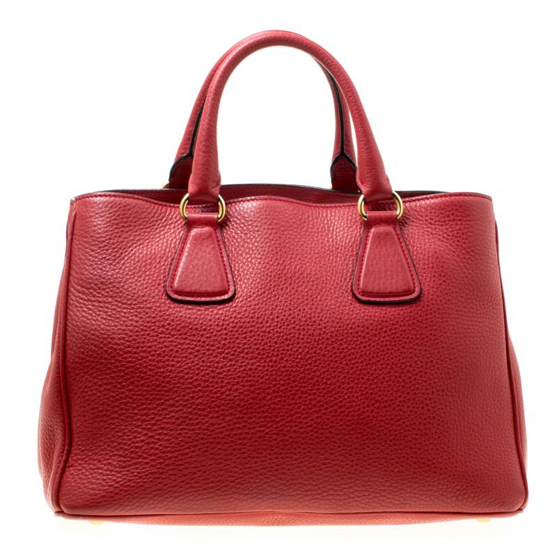 This polished creation from Prada flaunts the brand logo on the front. It is crafted from grain leather and is perfect for daily use. The bag features double handles, a leather tag and a removable shoulder strap. The nylon lined interior is spacious