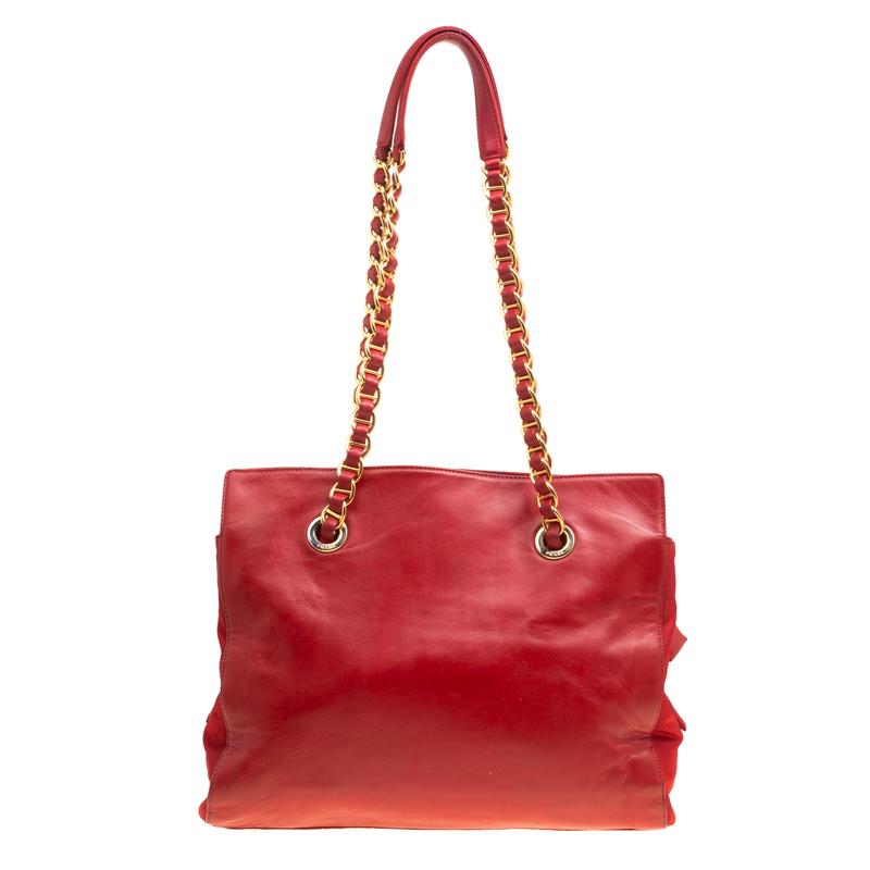 You're all set to become the centre of attraction when you step out swinging this fabulous tote from Prada. This red tote is crafted from leather and nylon and features a minimalistic design. It flaunts an embossed brand logo at the front and dual