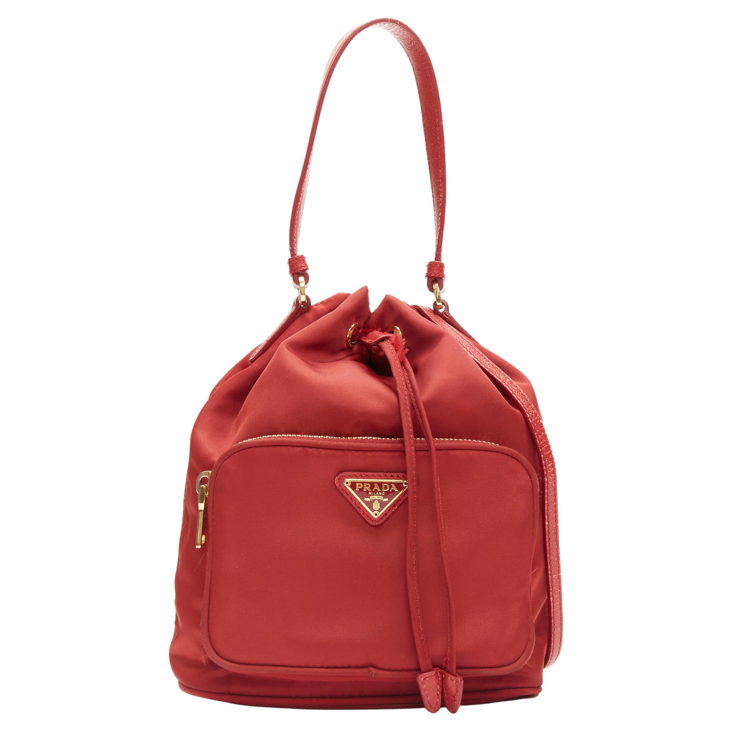 PRADA sac à bandoulière à cordon de serrage en nylon rouge et plaque triangulaire dorée en vente