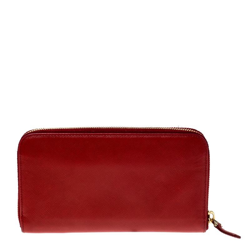 Store your daily essentials with this wallet from Prada. Add a touch of luxury to your everyday style with this red wallet. Durable and long-lasting, this zip-around wallet is crafted from fine quality Saffiano leather.

