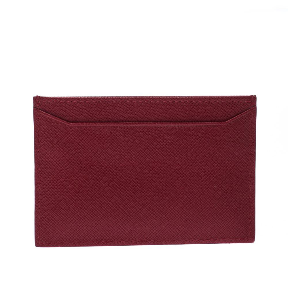 This Prada card holder is conveniently designed for everyday use. Crafted from red Saffiano leather, the piece comes with slots and the brand logo in gold-tone at the front. It is durable and lightweight.

Includes: Original Box, Authenticity Card

