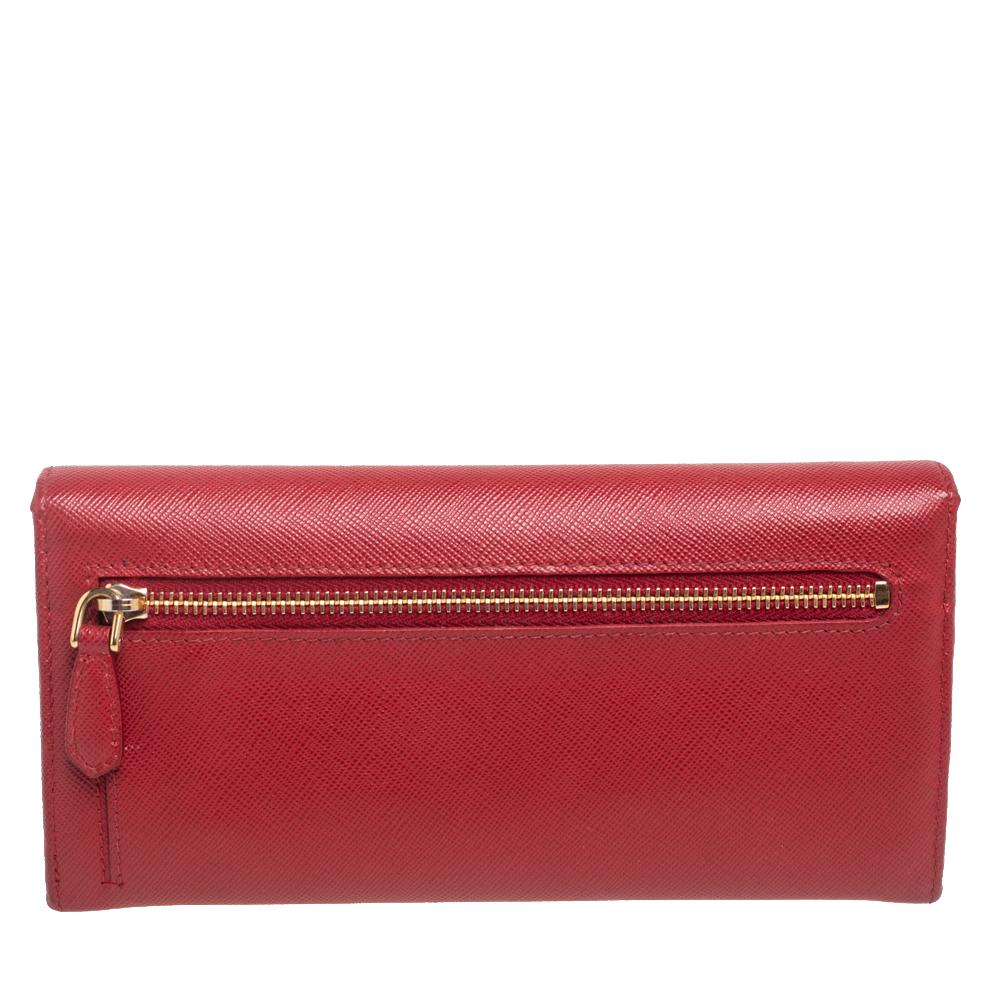 This designer continental wallet by Prada has a beautiful look. Crafted from Saffiano Lux leather, it comes in a red shade. It has a front flap with a bow detail that adds charm and its lined interior has enough space for all your