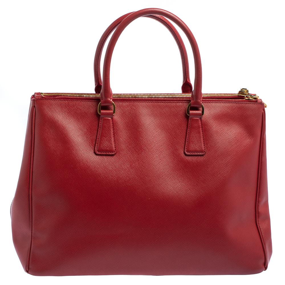 Feminine in shape and grand on design, this Double Zip tote by Prada will be a loved addition to your closet. It has been crafted from leather and styled minimally with gold-tone hardware. It comes with two top handles, two zip compartments, and a