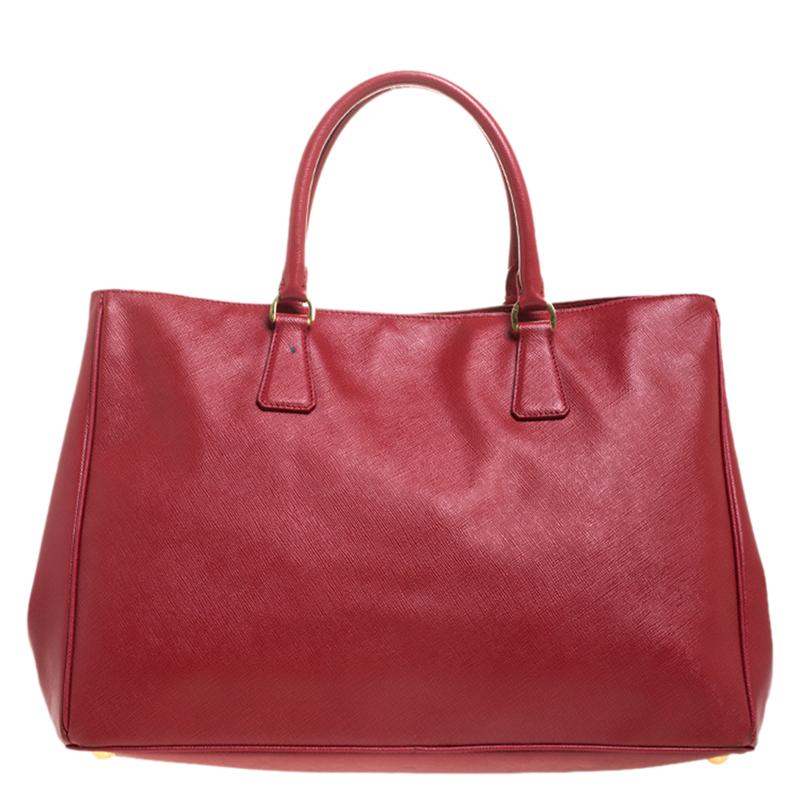 High in appeal and style, this Gardener's tote is a Prada creation. It has been crafted from Saffiano Lux leather and shaped to exude class and luxury. The red bag comes with two handles and a spacious nylon interior with enough space for your ease.