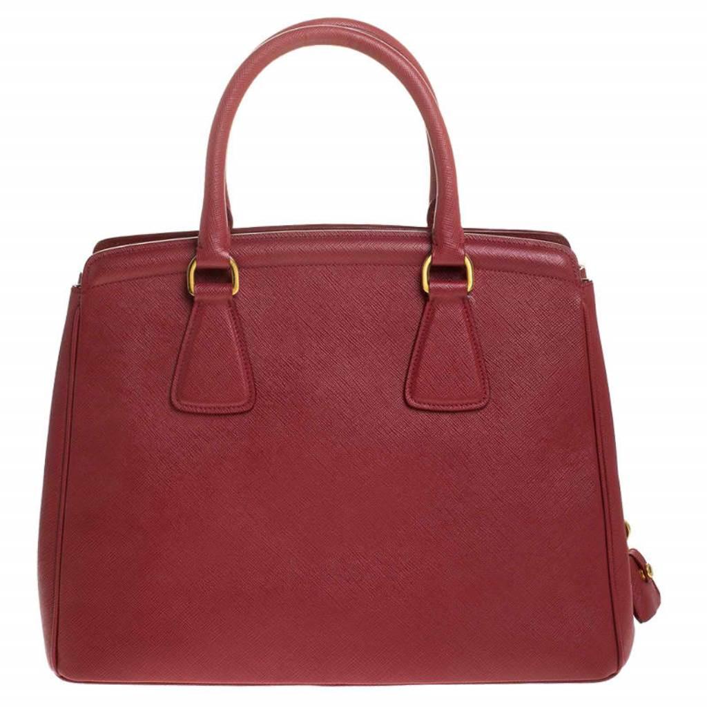 Masterfully created, this Prada tote is a style icon. Designed in a Saffiano Lux leather body, it exudes style and class in equal measures. This delightful red piece is held by two top handles and equipped with a spacious nylon interior.

Includes: