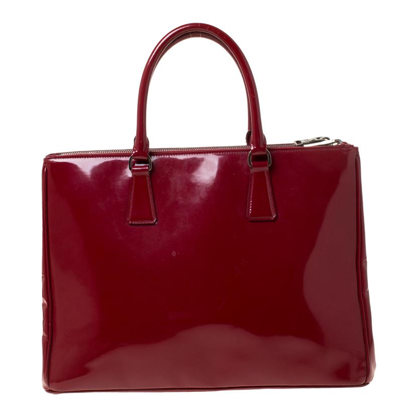 Feminine in shape and grand on design, this Double Zip tote by Prada will be a loved addition to your closet. It has been crafted from patent leather and styled minimally with silver-tone hardware. It comes with two top handles, two zip compartments
