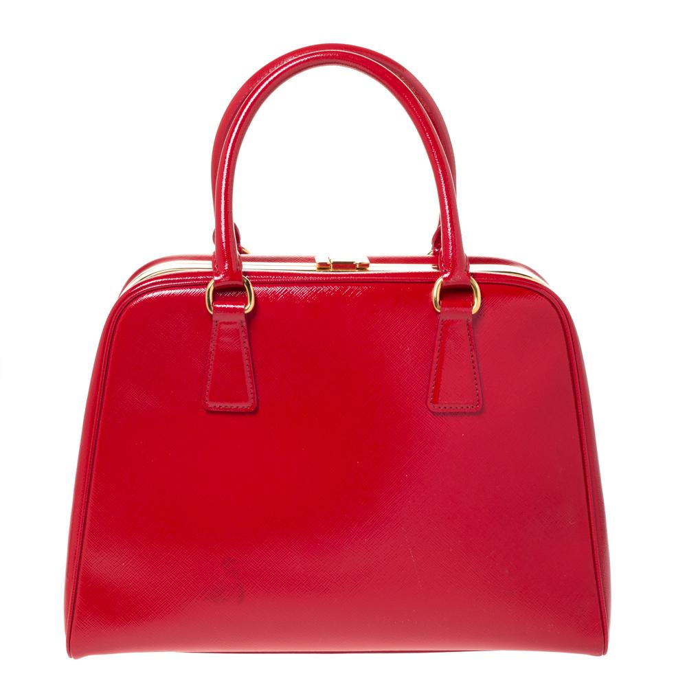 Diese Pyramiden-Tasche von Prada verleiht Henkeltaschen ein elegantes Update und ist eine wertvolle Ergänzung für Ihren Kleiderschrank. Sie wurde in Italien aus Saffiano Vernice Leder gefertigt. Er hat eine strukturierte Silhouette mit einer