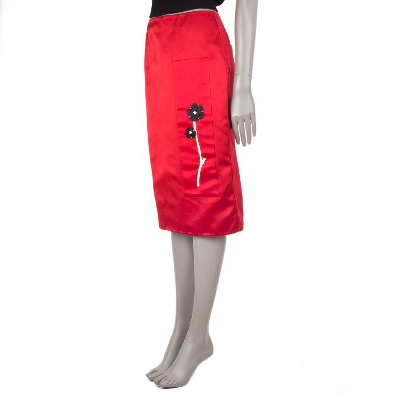 Prada pencil skirt in red silk satin (100%) with flower detail in black and white. Opens with zipper and hook on the back. Unlined. Has been worn and is in excellent condition.

Tag Size 40
Size S
Waist 72cm (28.1in)
Hips 92cm (35.9in)
Length 67cm