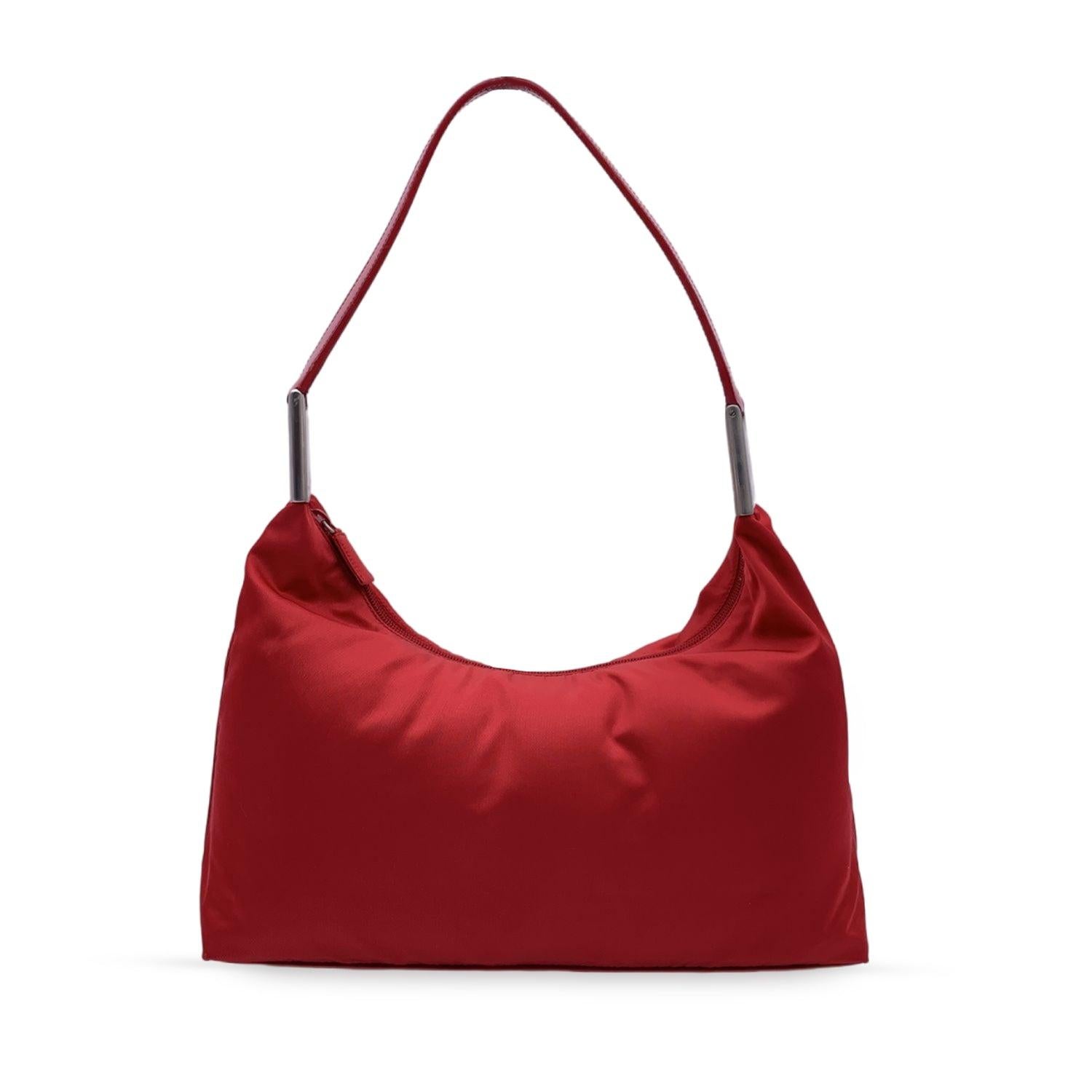 PRADA Hobo Shoulder Bag. Crafted in red tessuto nylon canvas with genuine leather shoulder strap. Silver metal hardware. Upper zipper closure. Red signature canvas lining. 1 side zip pocket. 'Prada Milano - Made in Italy' tag inside Condition A -