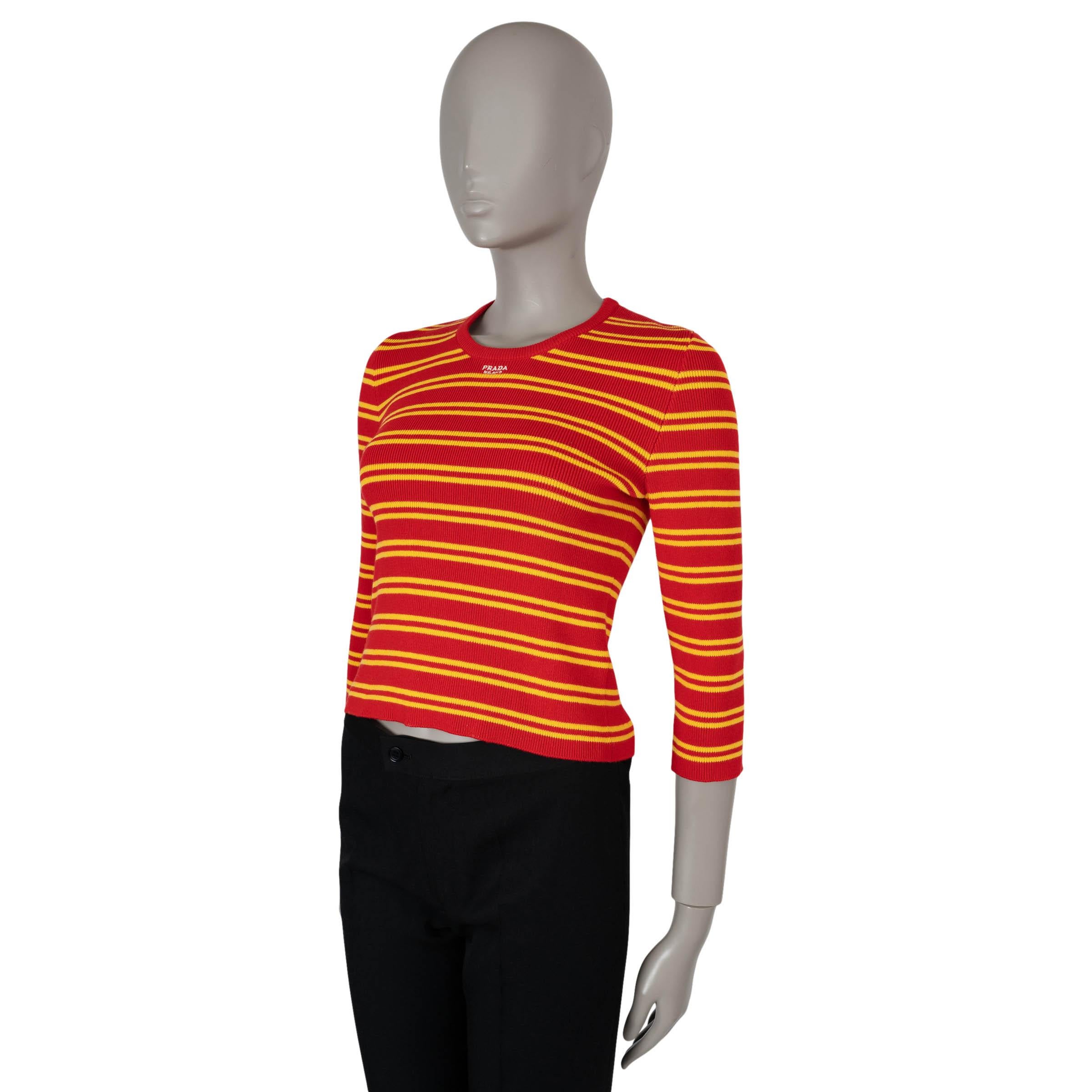 This 100% authentic Prada sweater in red rib-knit cotton (90%), polyamide (8%), and elastane (2%) brings a sporty-chic appeal with its bold yellow stripes. Designed with a cropped length, it features a classic crewneck, 3/4 sleeves, and a white