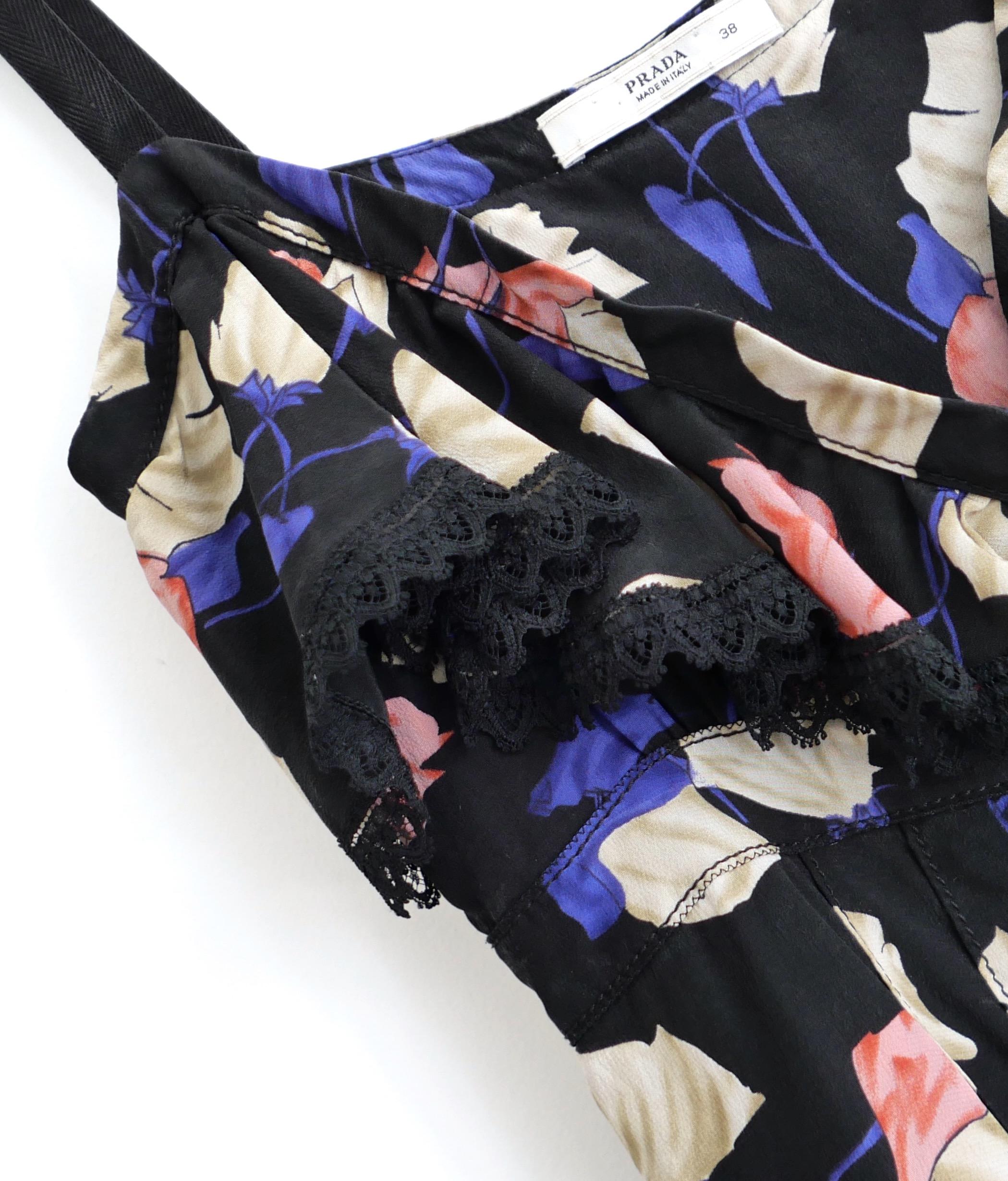 Absolutely gorgeous Prada floral blouse from the Resort 2008 collection. Made from black silk crepe with a gorgeous pink, purple and beige poppy print, it has delicate lace trims and cotton webbing straps. Beautifully cut with flat stitched pleated