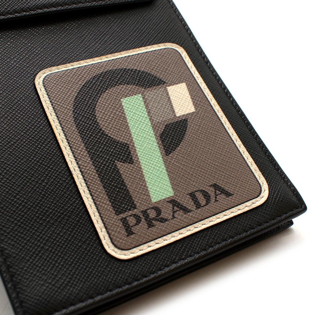 Prada Runway Black Saffiano Leather Smartphone Case

This Saffiano leather cellphone case can be conveniently worn with a shoulder strap and has a badge holder on the back. The flap closes with a snap button and the front is decorated with a leather