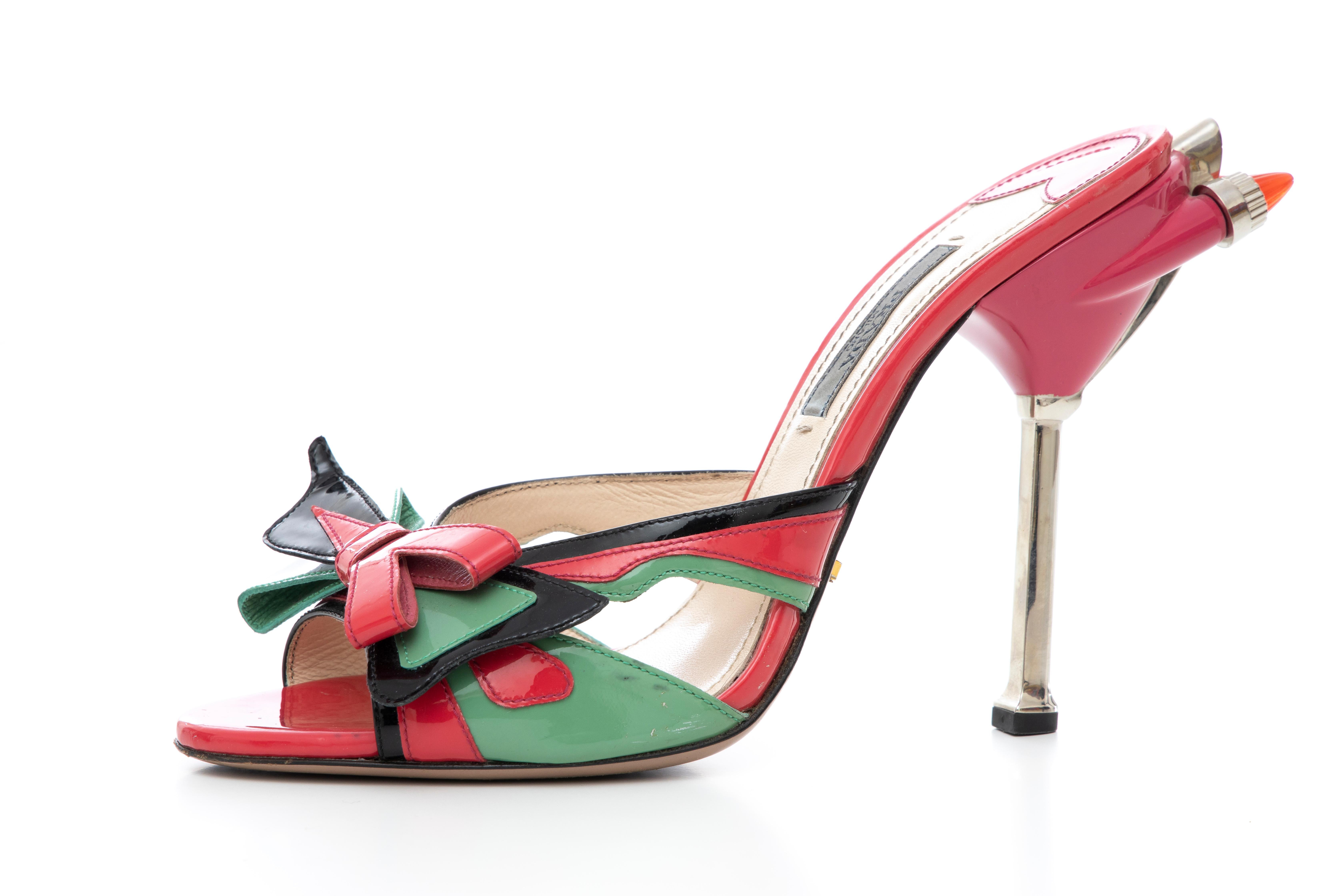 Prada, Spring-Summer 2012, patent leather Hot Rod slide sandals with bow accents at uppers and tail light embellishments at heels.

Heels: 5

IT. 37.5
US. 7.5