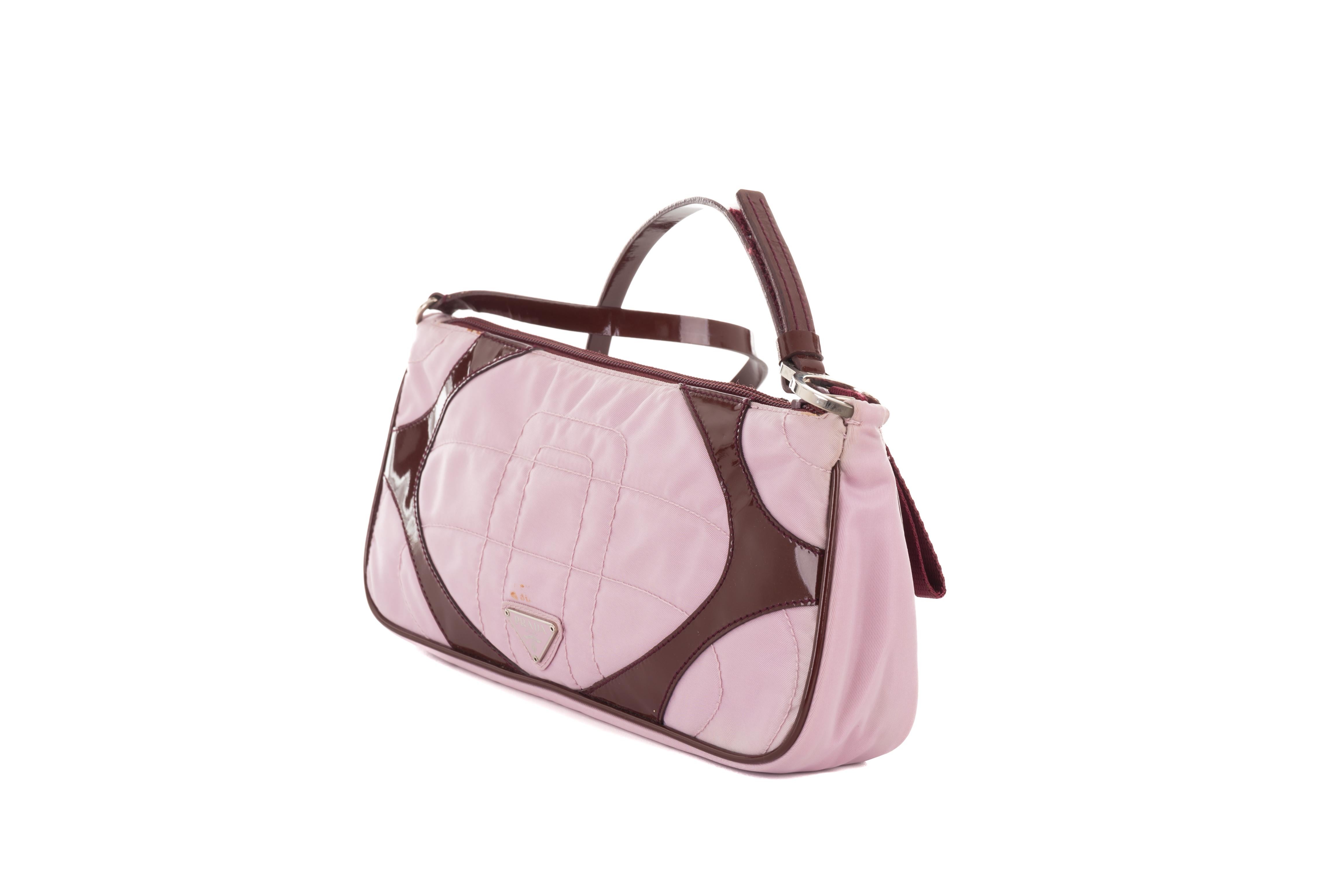 - Prada by Miuccia Prada
- Spring-summer 2000 collection
- Sold by Gold Palms Vintage
- Pink nylon quilted mini bag
- Burgundy patent leather detailing and strap 
- Front pink logo
- Small stain on the front (reflected on price)