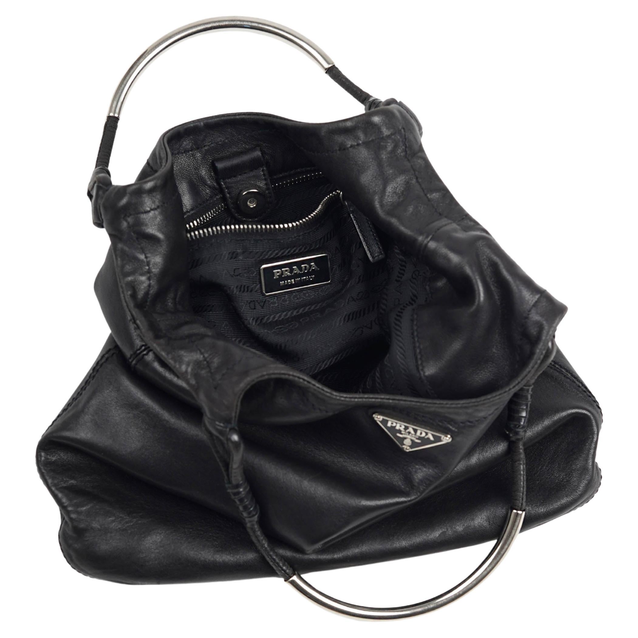 This rare Prada handbag from the Spring/Summer 2003 collection is a standout example of early 2000s Prada — minimal, sculptural, and effortlessly modern. Designed under Miuccia Prada, the piece reflects the era’s refined utilitarianism and
