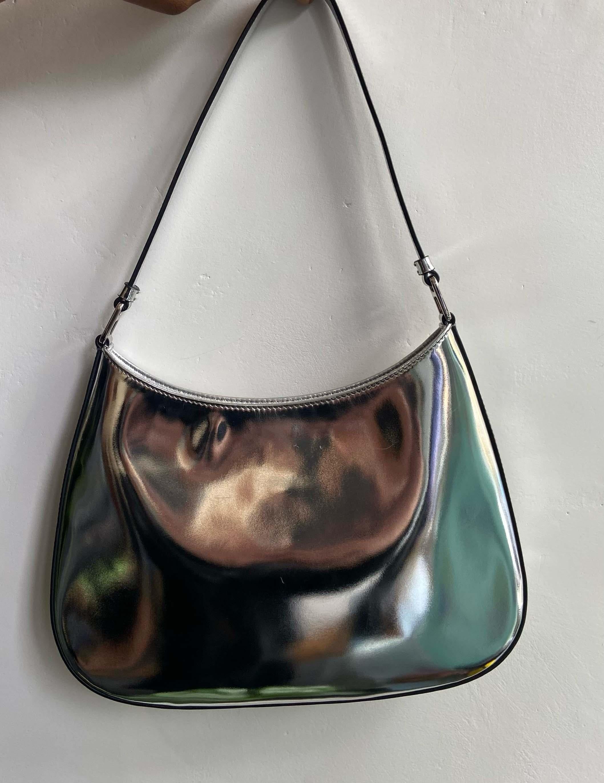 Prada silver Cleo S/S 2023 shoulder bag. metallic silver body, signature triangular enamel logo plaque on front, silver interior with back pocket. This current season's bag is a re-imagination of the iconic 1990's style by Prada. In great to