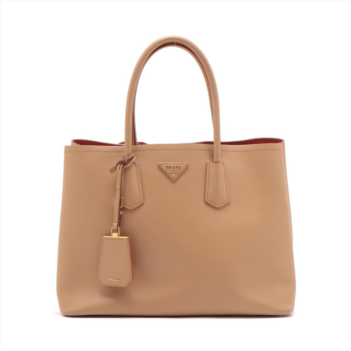The Prada Saffiano Cuir Two-Way Tote Bag in Beige is a versatile and luxurious accessory that effortlessly combines style and functionality. Crafted from the finest Saffiano leather, known for its durability and distinctive crosshatch texture, the