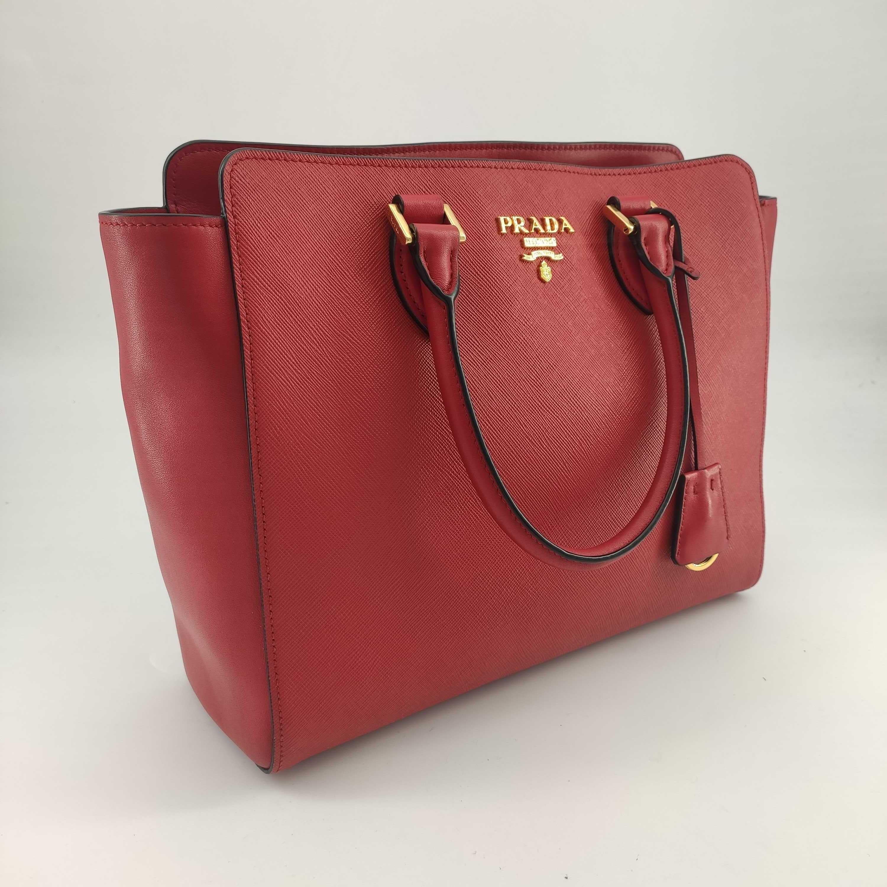 - Designer: PRADA
- Model: Saffiano
- Condition: Very good condition. 
- Accessories: Dustbag, Authenticity Card
- Measurements: Width: 29cm, Height: 24cm, Depth: 10cm
- Exterior Material: Leather
- Exterior Color: Red
- Interior Material: Cloth
-