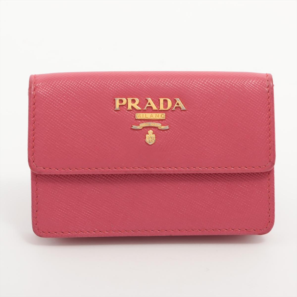 The Prada Saffiano Leather Card Case in Pink is a sleek and sophisticated accessory, perfect for keeping your essentials organized in style. Crafted from luxurious Saffiano leather, known for its durability and distinctive crosshatch texture, the
