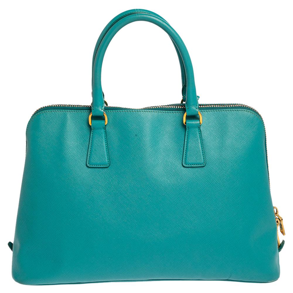 This stunning Promenade tote is high on appeal and style. Dazzling in a classy aqua blue shade, the bag is crafted from Saffiano leather and features two rolled handles. The zip closure leads way to a nylon and leather interior with enough space for