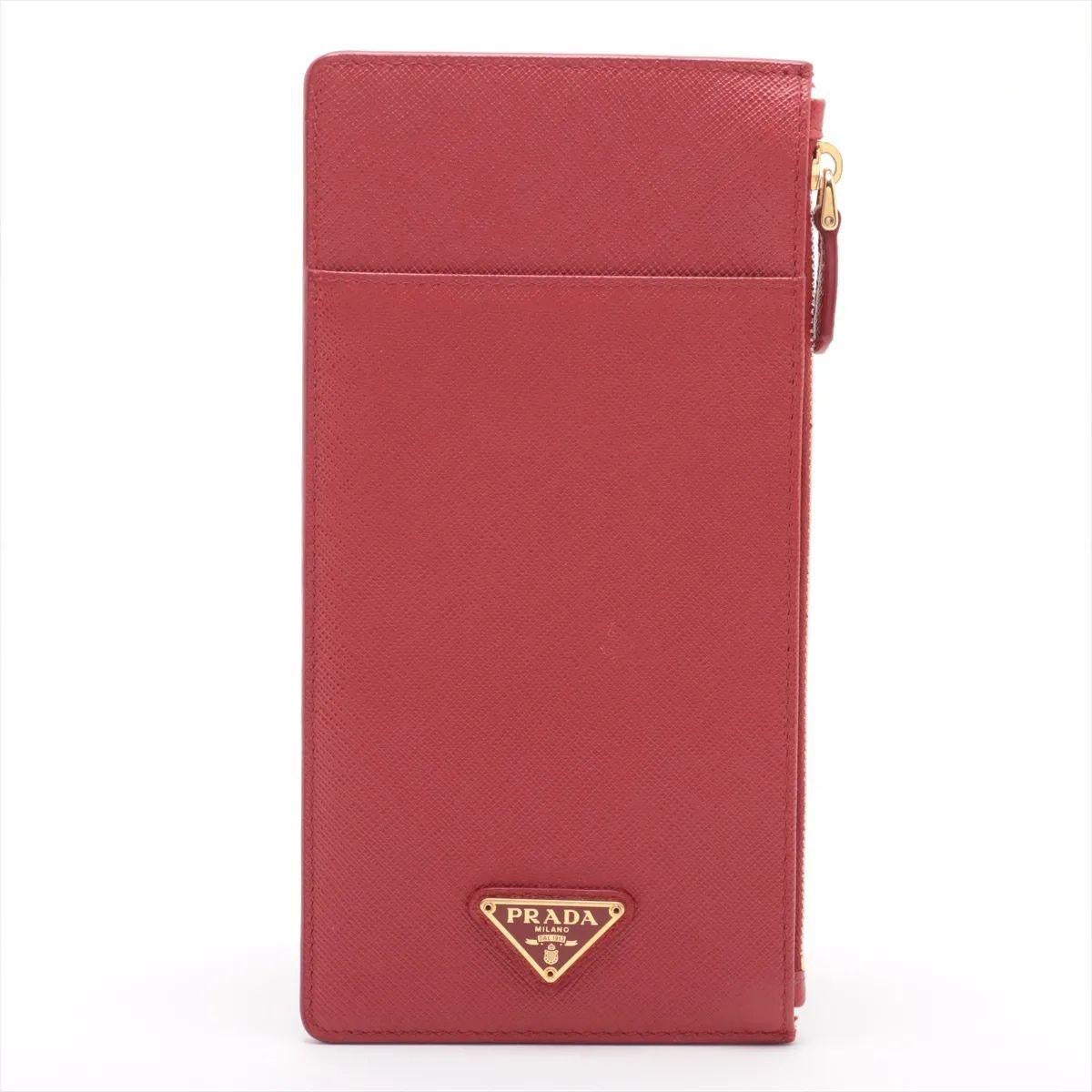 Das Prada Saffiano Leder Portemonnaie in Rot ist ein schlichtes und elegantes Accessoire, das sowohl Stil als auch Funktionalität bietet. Sie ist aus strapazierfähigem Saffiano-Leder gefertigt, das für seine Kreuzschraffur und seine