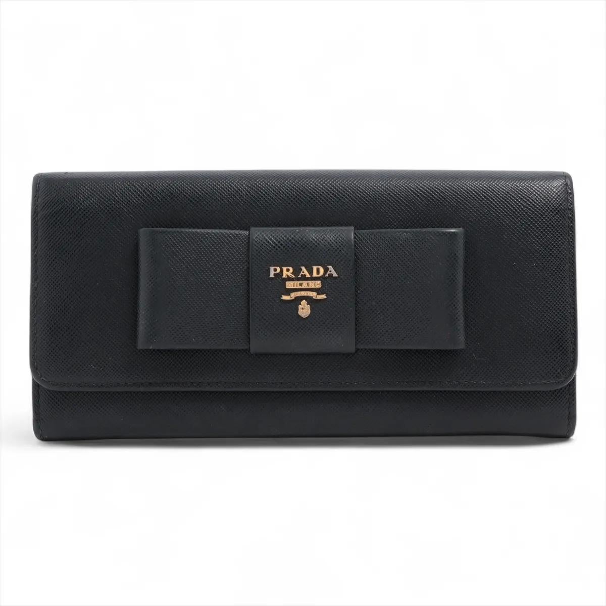 Il portafoglio lungo con nastro in pelle saffiano di Prada in nero emana un'eleganza senza tempo e una raffinata ricercatezza. Realizzato in pelle saffiano, è resistente e dalla texture splendida, a dimostrazione dell'impeccabile maestria di Prada.