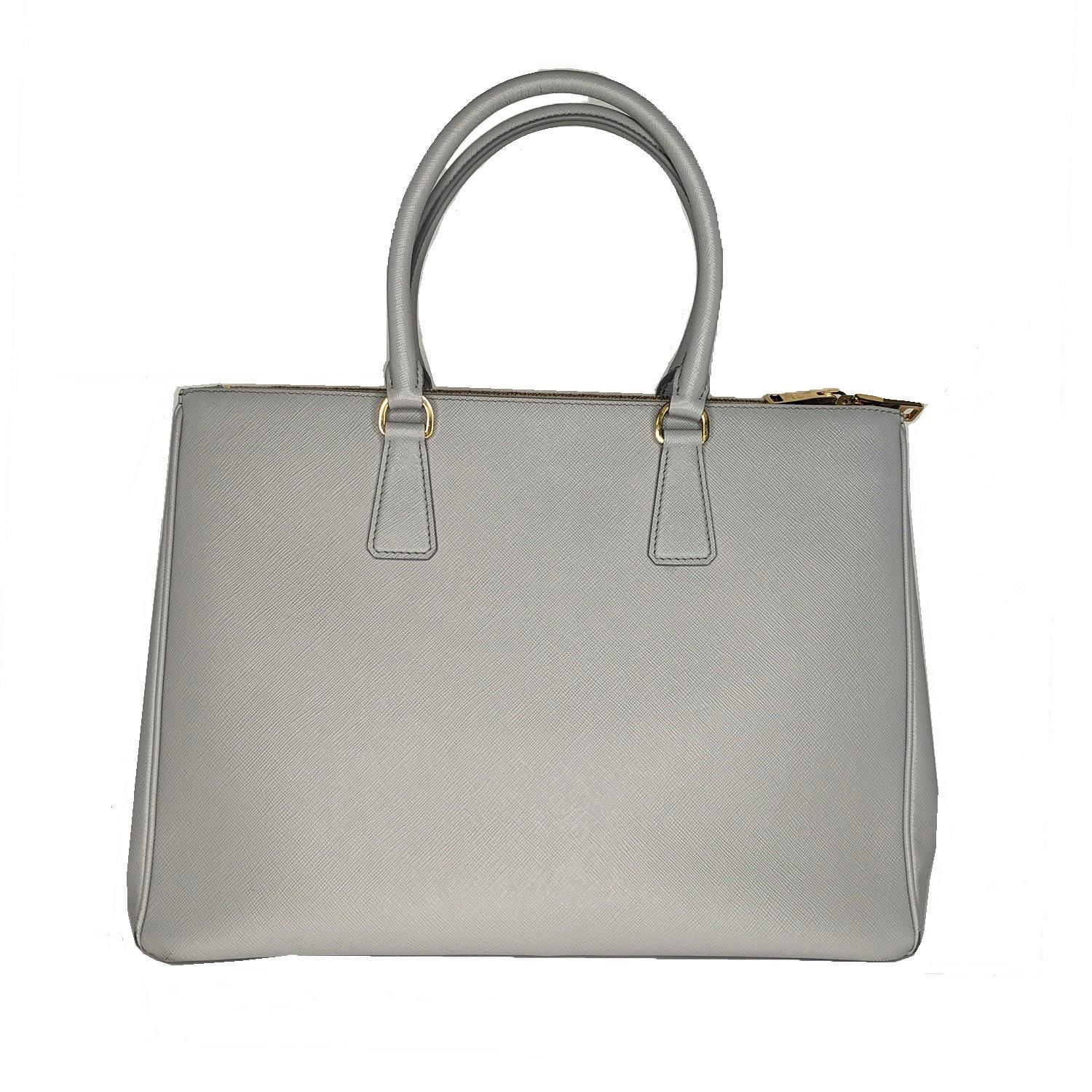 This stunning Prada Saffiano Lux Leather Galleria Tote Bag 1BA786 is one sophisticated piece. This durable and spacious tote features a structured tote shape in Saffiano lux leather and silvertone hardware. The bag comes with a long strap and a