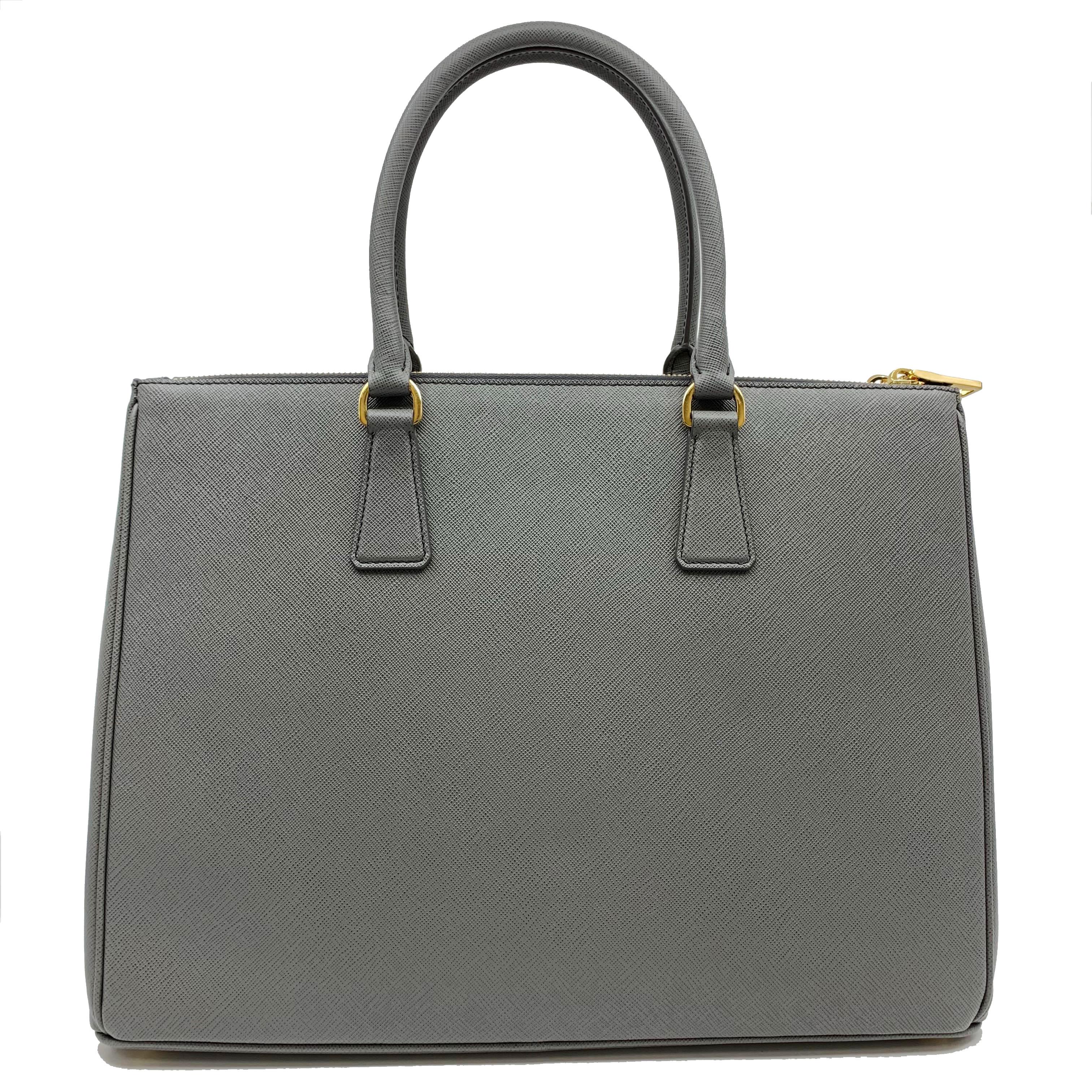 Prada's Galleria saffiano tote is a perfectly prim addition to your accessories edit. Crafted from textured gray calf leather, this design is finished with dainty top handles and golden hardware. Double storage compartments leave ample room for