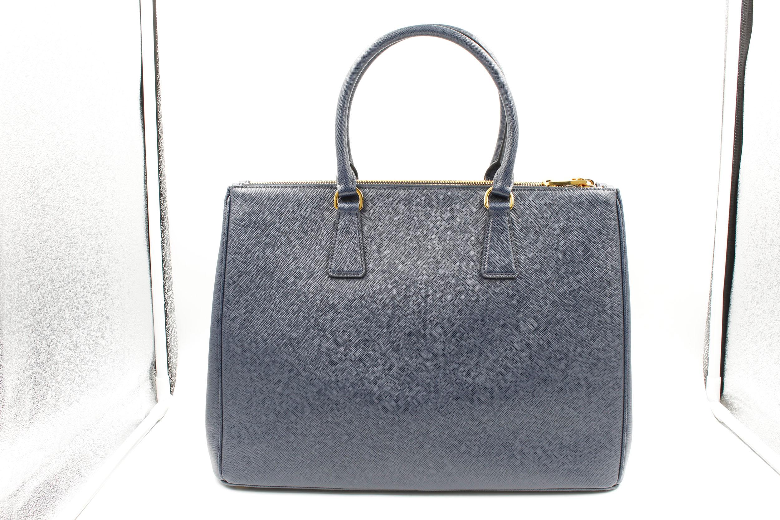 Prada's Galleria Saffiano tote is a perfectly prim addition to your accessories edit. Crafted from textured navy blue calf leather, this design is finished with dainty top handles and golden hardware. Double storage compartments leave ample room for