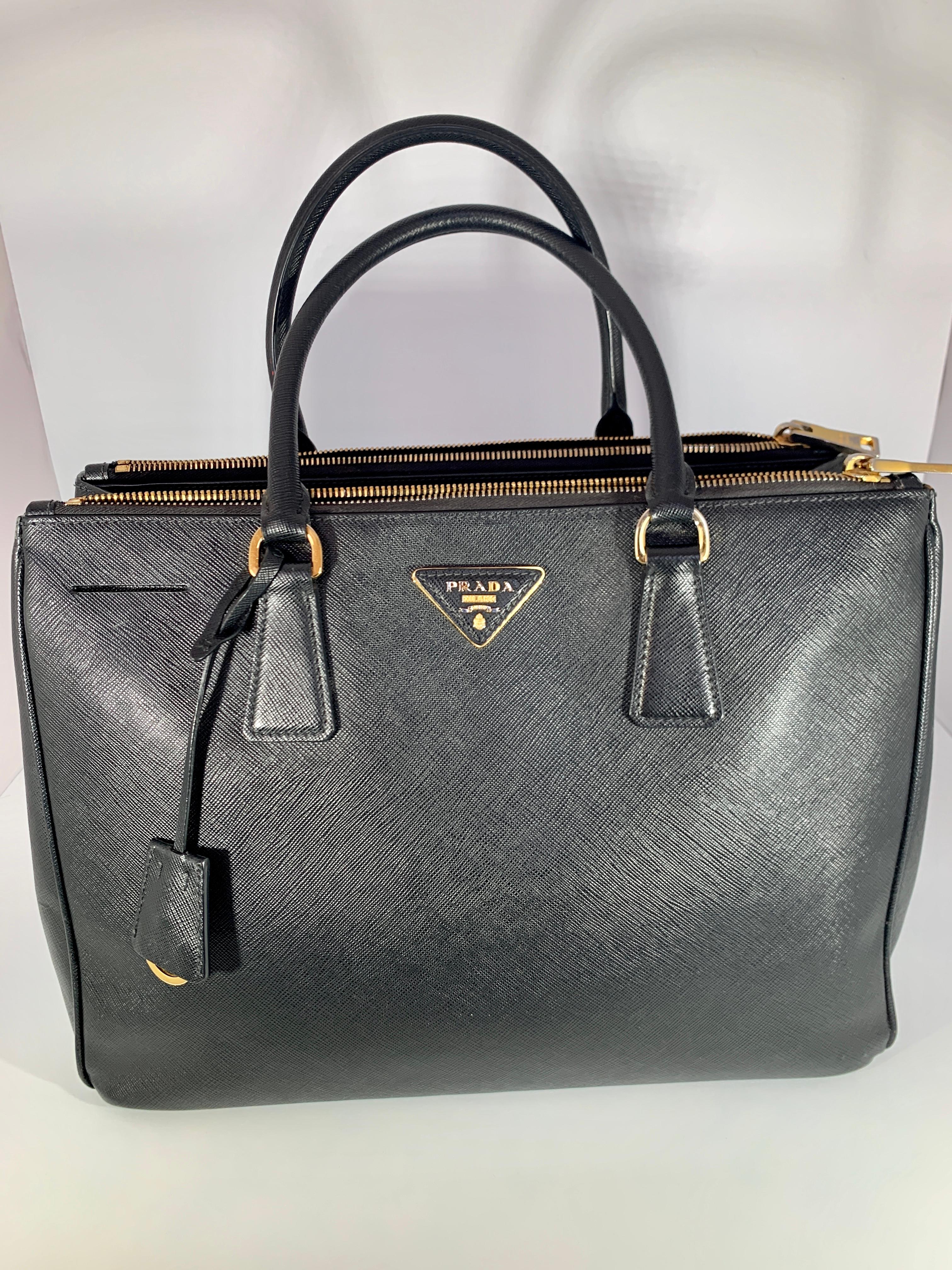 Prada Saffiano Lux Double-Zip Tote Bag, Black
Boxy saffiano leather top handle bag with polished hardware and a removable crossbody strap. Double top handles Removable, adjustable shoulder strap Side-snap gussets Open top Goldtone hardware Two
