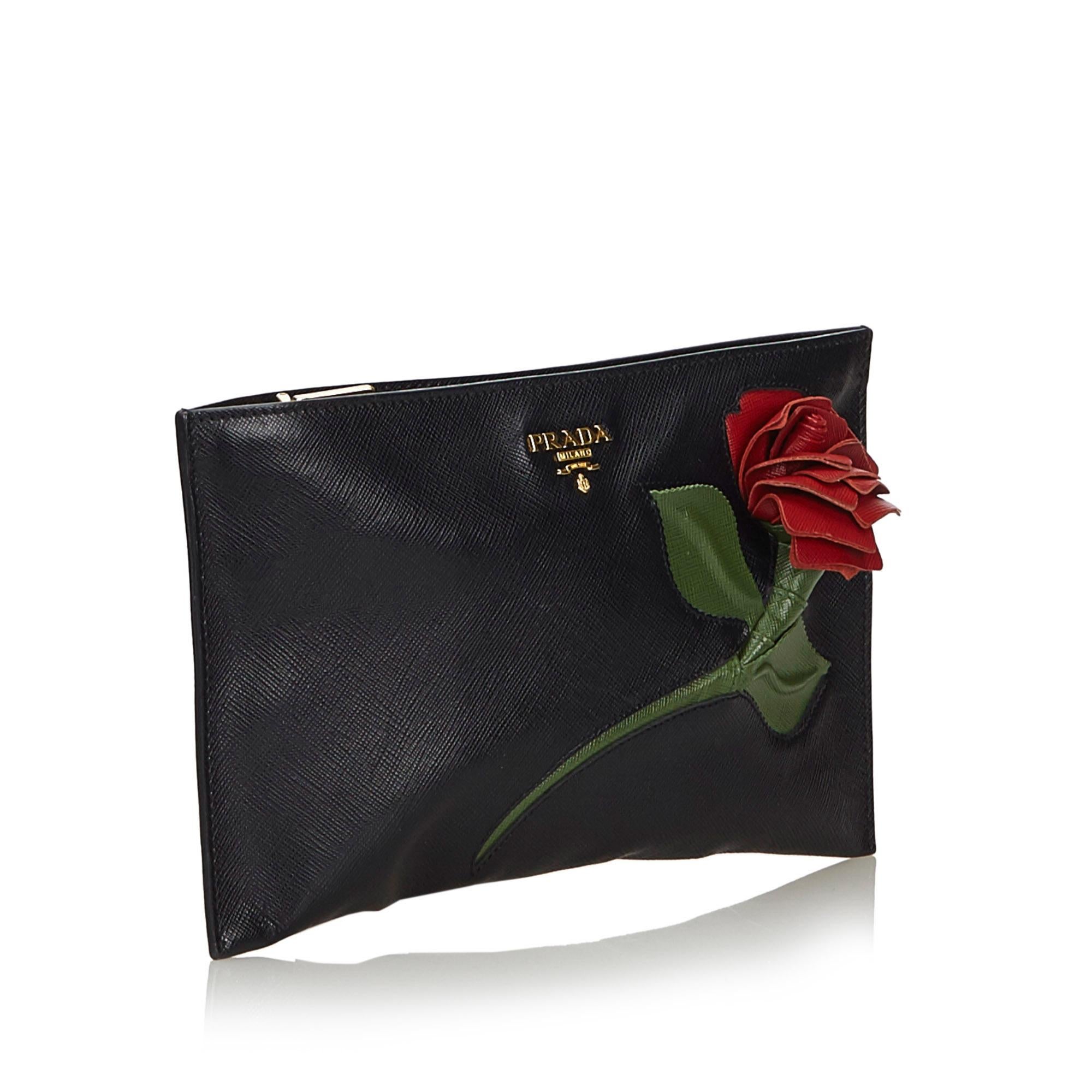 Prada Saffiano Leather Clutch Bag

This clutch bag features a saffiano leather body, a rose detail, a top zip closure, and interior zip and slip pockets. 

Approx. 

Length: 15 cm. Width: 25 cm. 
Depth: 0.5 cm.
