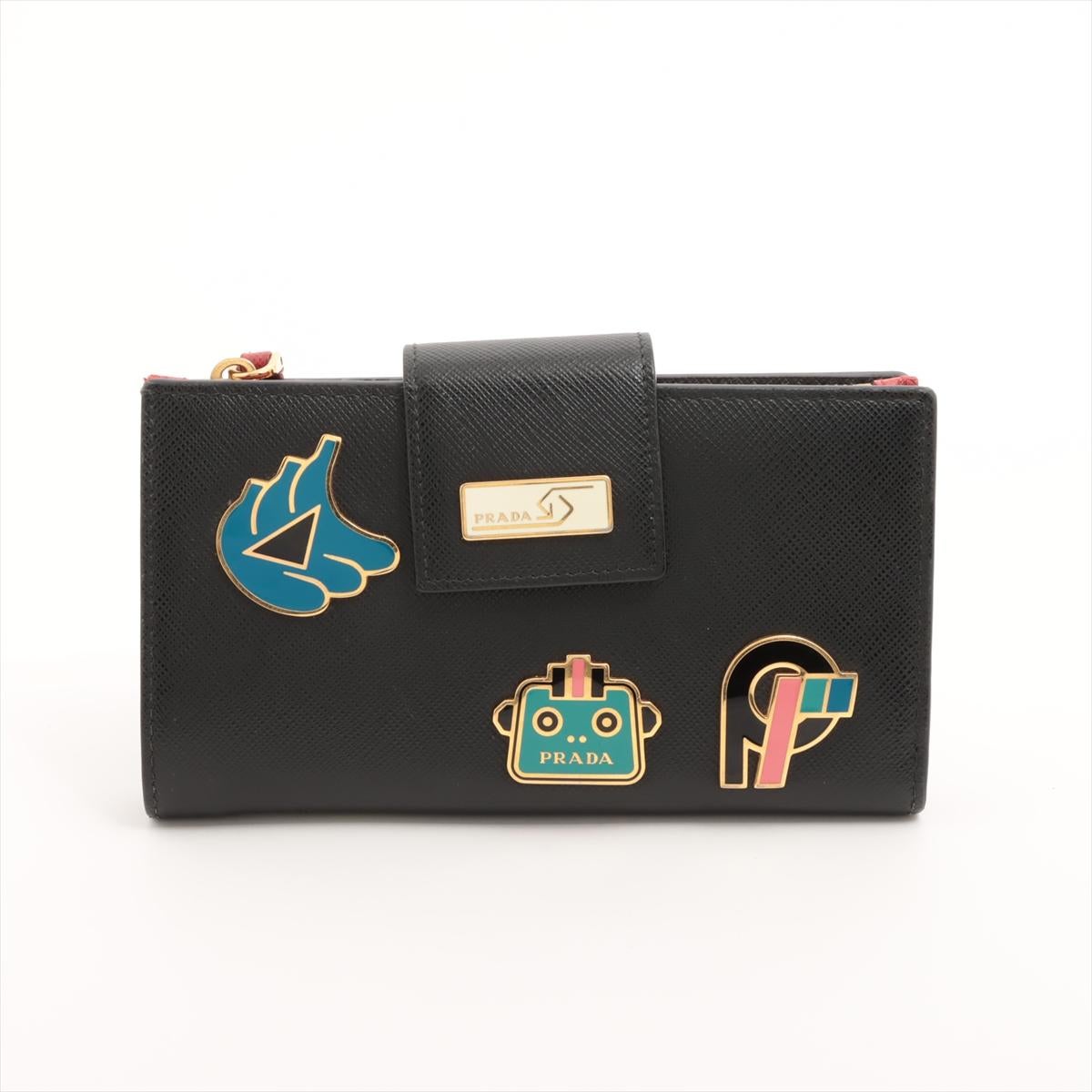 The Prada Saffiano Smarto Robot Leather Wallet in Black is a stylish and playful accessory that combines luxury with a futuristic edge. Crafted from durable Saffiano leather, the wallet features iconic Prada robot logo on the front and other Prada
