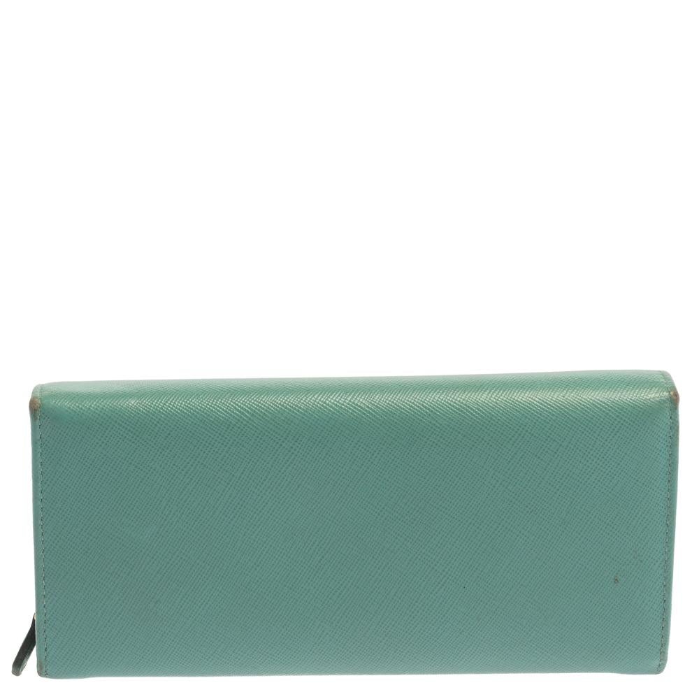 Durable and long-lasting, this wallet from Prada is crafted from Saffiano lux leather. Featuring a lovely sea green shade, it flaunts a front flap that is adorned with a gold-tone brand logo detailing and opens to a leather and fabric interior that