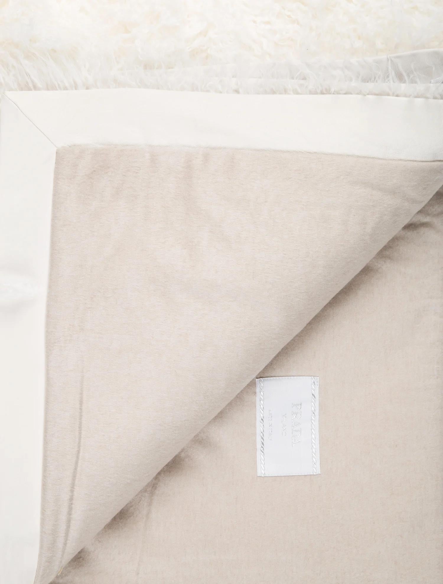 White shearling Mongolian wool throw blanket by Prada.

Tan wool backing and leather trim. 

Measures: 60