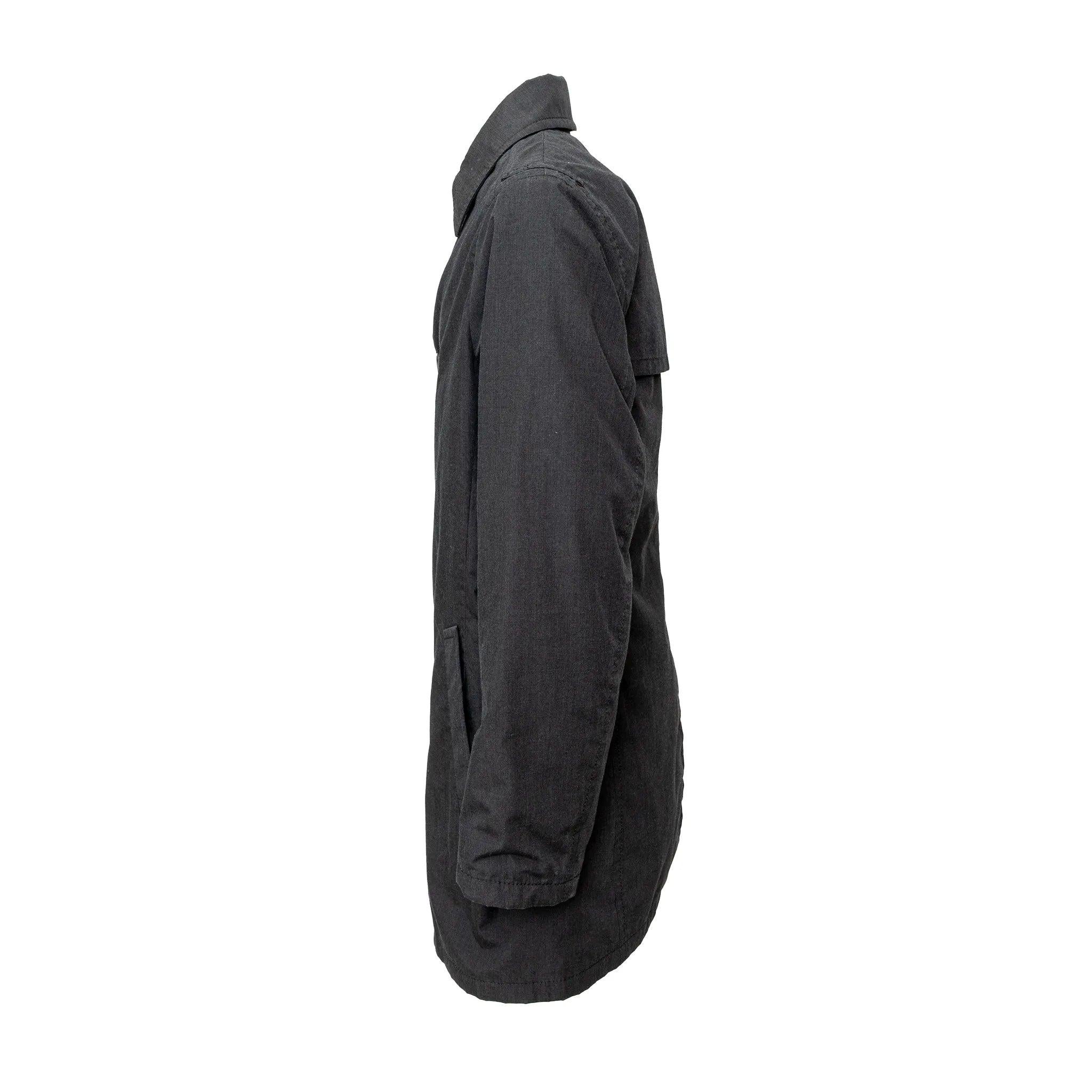 Trench di Prada in grigio antracite, un vero trench in misto kevlar. Silhouette corta con colletto classico e bottoni frontali. 
 Osservazioni: ci sono piccole imperfezioni sulla manica. 
 Materiale: 90% poliestere 10% kevlar 
 Misure: