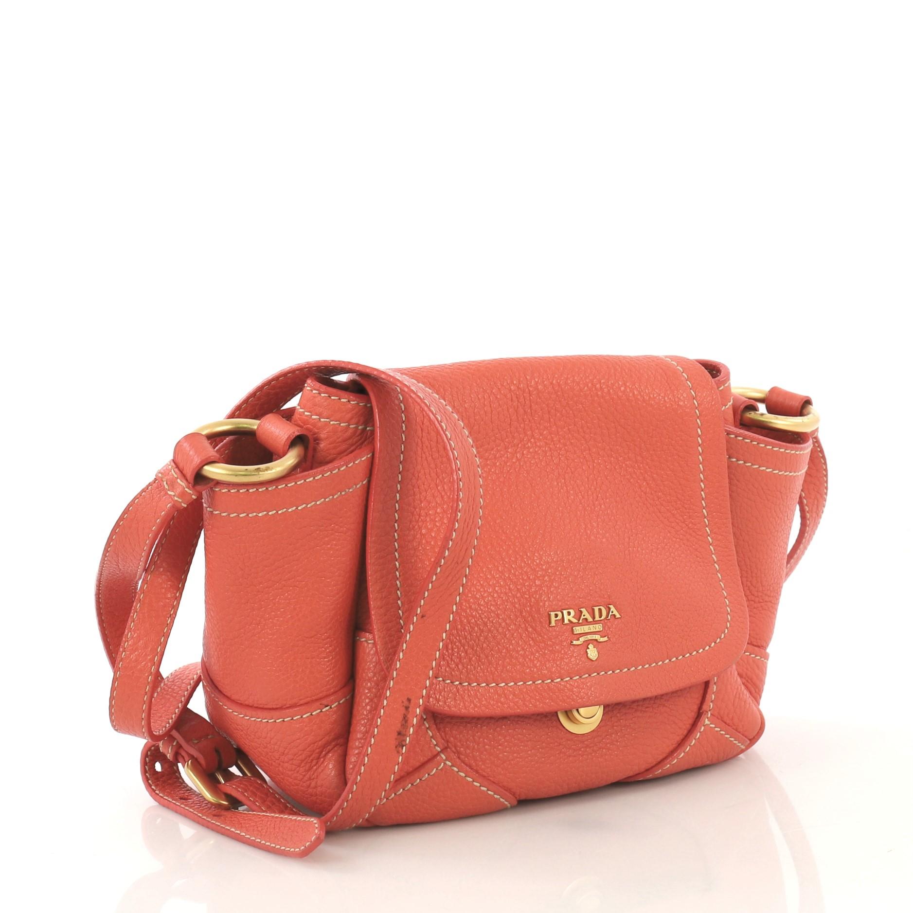 This Prada Side Pocket Crossbody Bag Vitello Daino Mini, crafted from orange vitello daino leather, features a flat leather handle, two exterior side flat pockets, and matte gold-tone hardware. It opens to an orange fabric interior with side slip