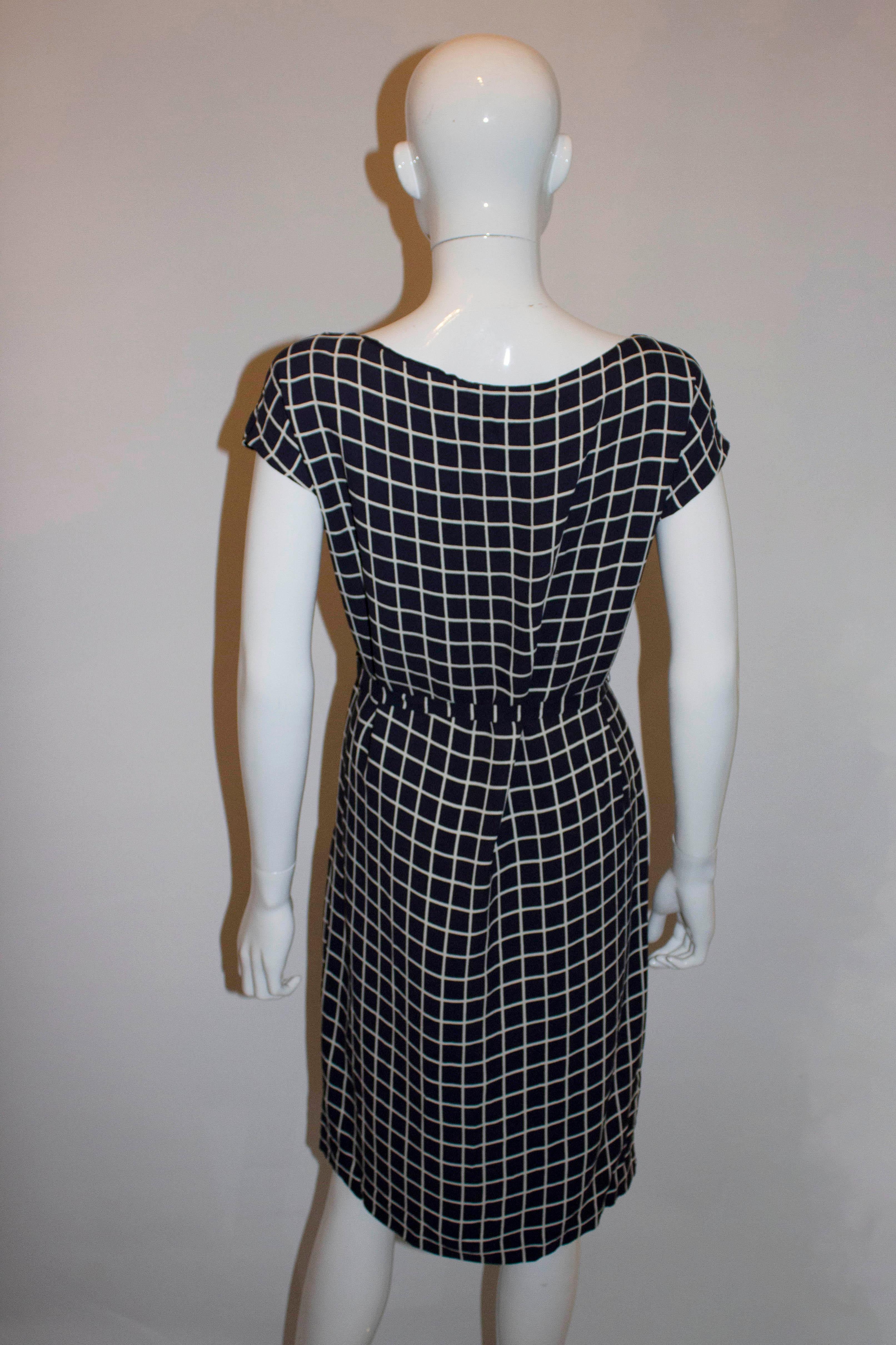 A chic blue and white silk dress by Prada . In a square ( quadretto ) print, the dress is lined in silk and has a self fabric belt.  Size 42'', Measurements Bust up to 39'', length 37''