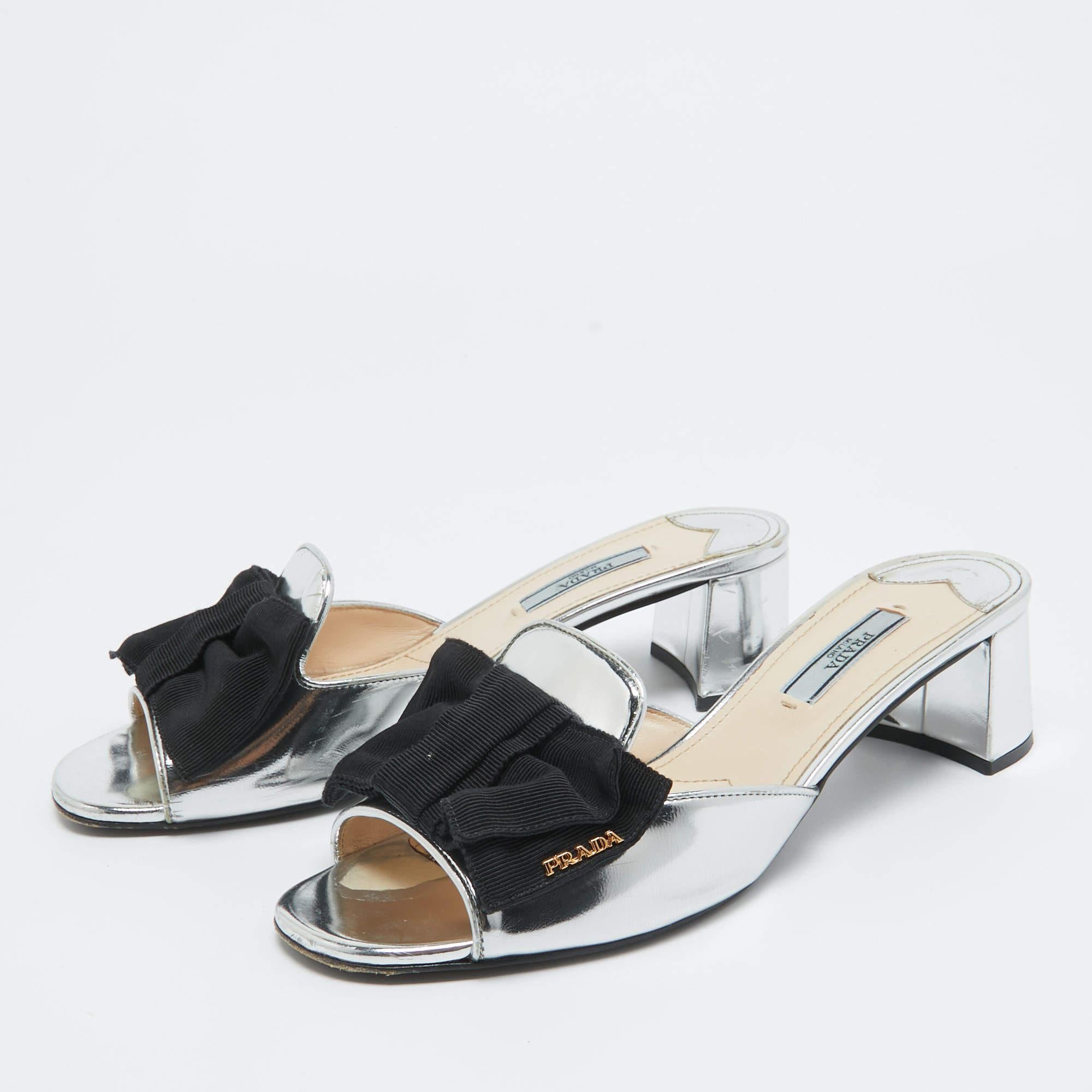 Discover footwear elegance with these Prada silver slides. Meticulously designed, these heels marry fashion and comfort, ensuring you shine in every setting.