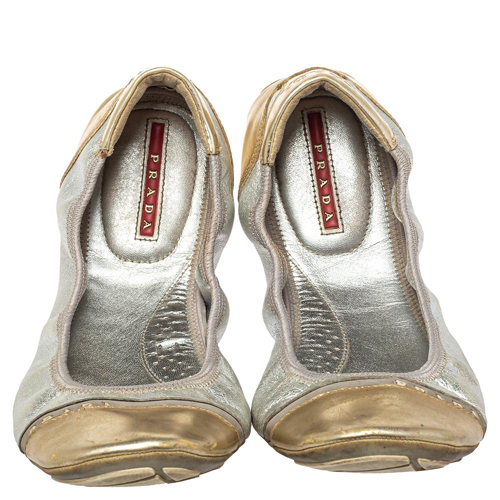 Artistically designed to hug your feet, these Prada ballet flats are too hard to miss. They feature a scrunched silhouette crafted from silver & gold patent leather and leather. They feature logo detailing and rubber soles for comfort.

Includes: