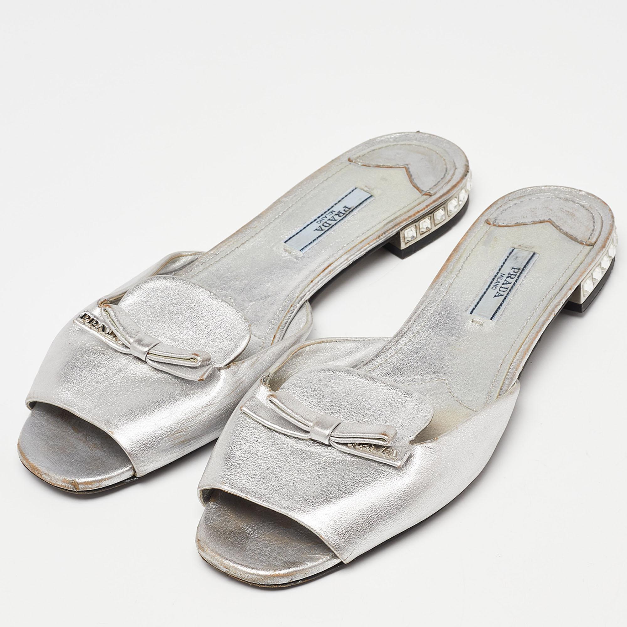 How pretty are these flat slides from the house of Prada! They've been crafted from leather and designed with a bow on the uppers and jewels on the heels. You can wear them with your casual outfits or with dresses.