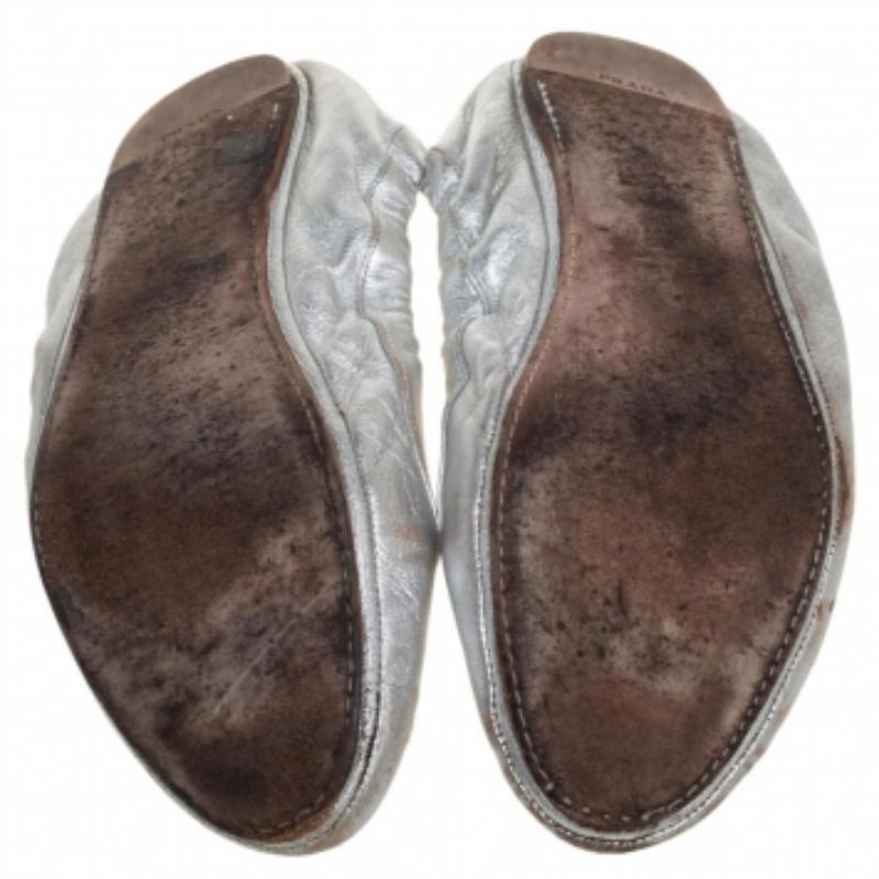 When comfort meets style, we get these minimally designed ballet flats by Prada. Made in Italy from silver leather, they feature round toes, scrunch detailing, and comfortable insoles.